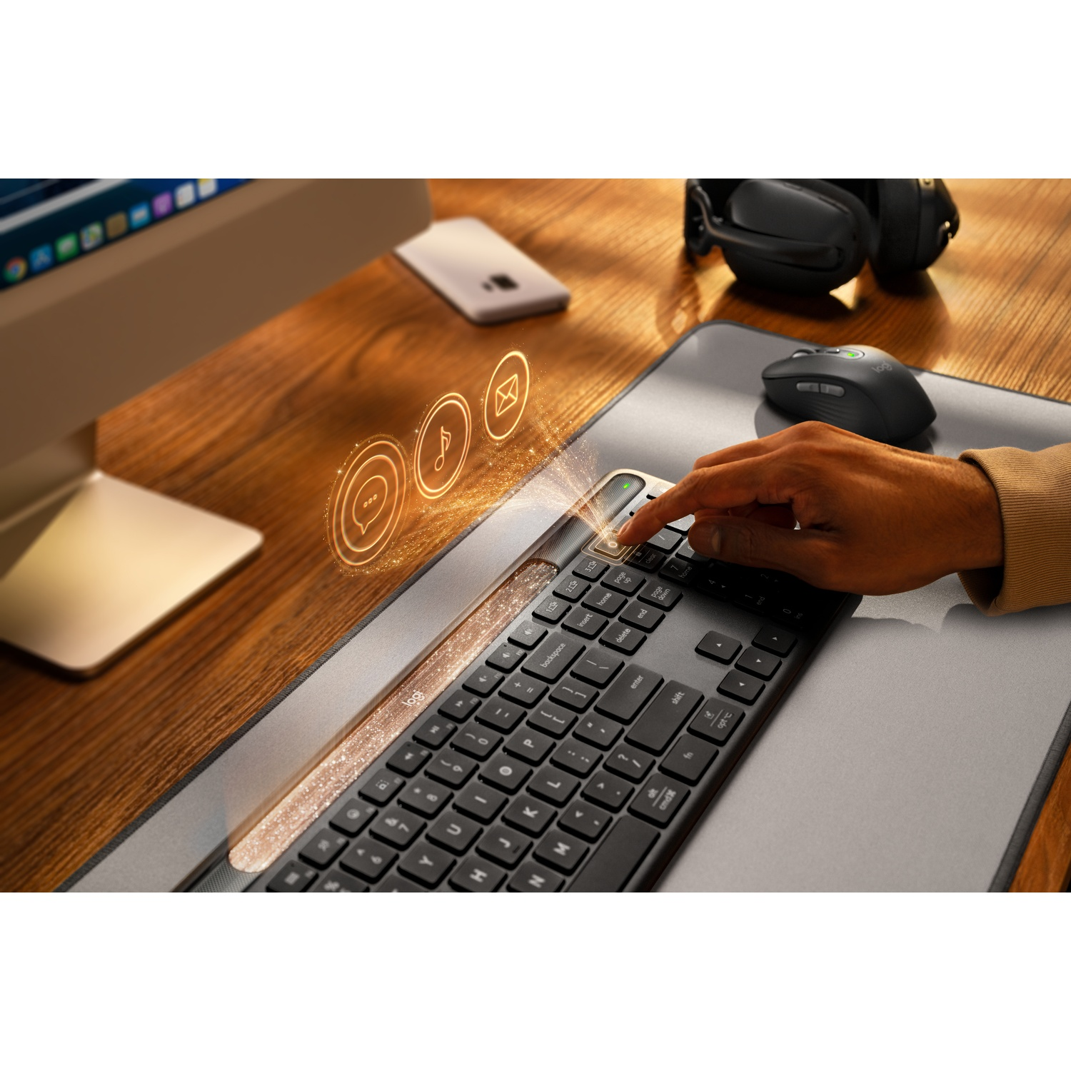 Una mano digita su una tastiera nera. Sopra fluttuano icone di chat, musica ed e-mail. Sono presenti anche un mouse e delle cuffie.