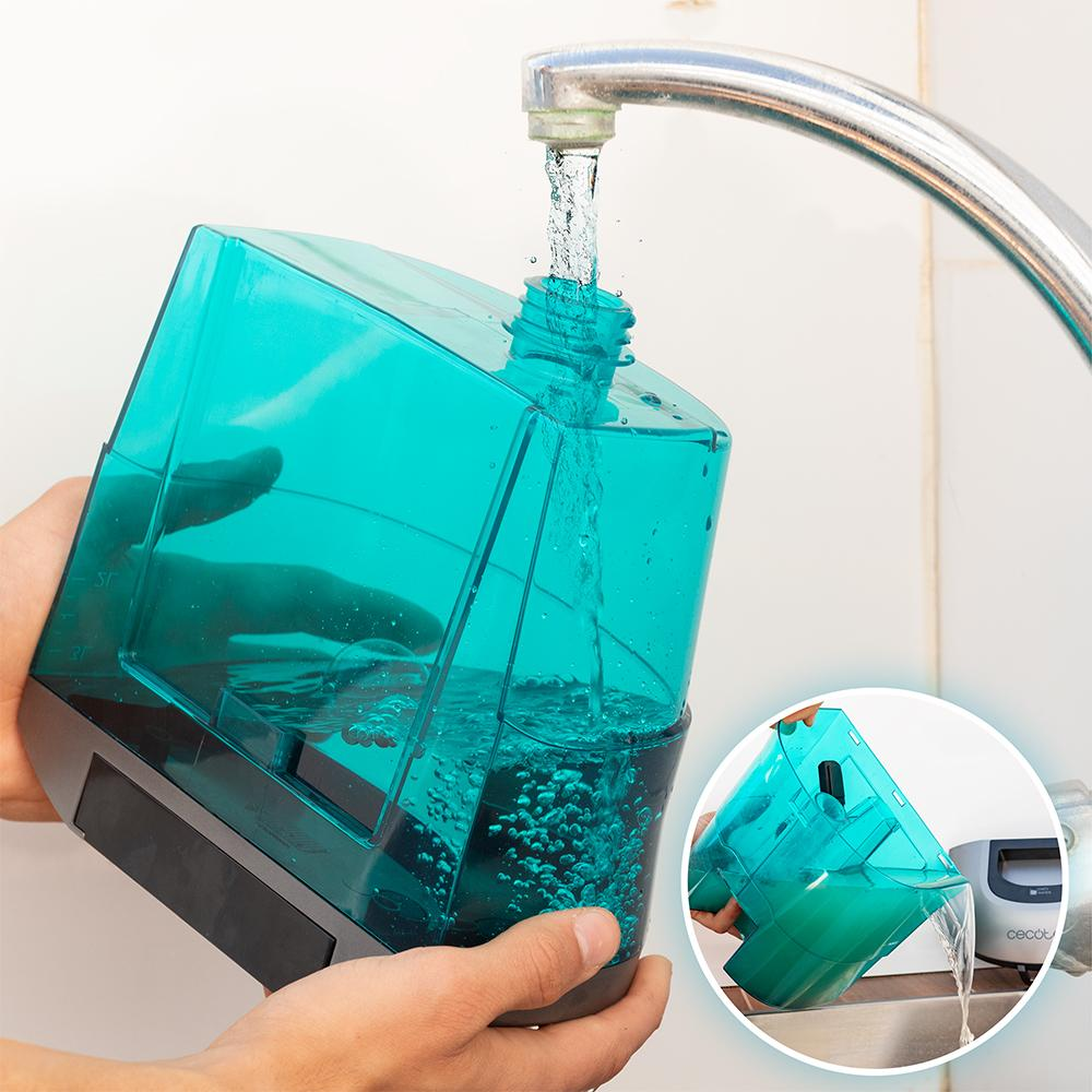 Una persona llena un recipiente color verde azulado con agua del grifo. El recipiente tiene medidas.