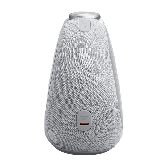 Szary głośnik z materiałową osłoną. Ma przyciski na górze i port ładowania na dole. Tło jest czarne.