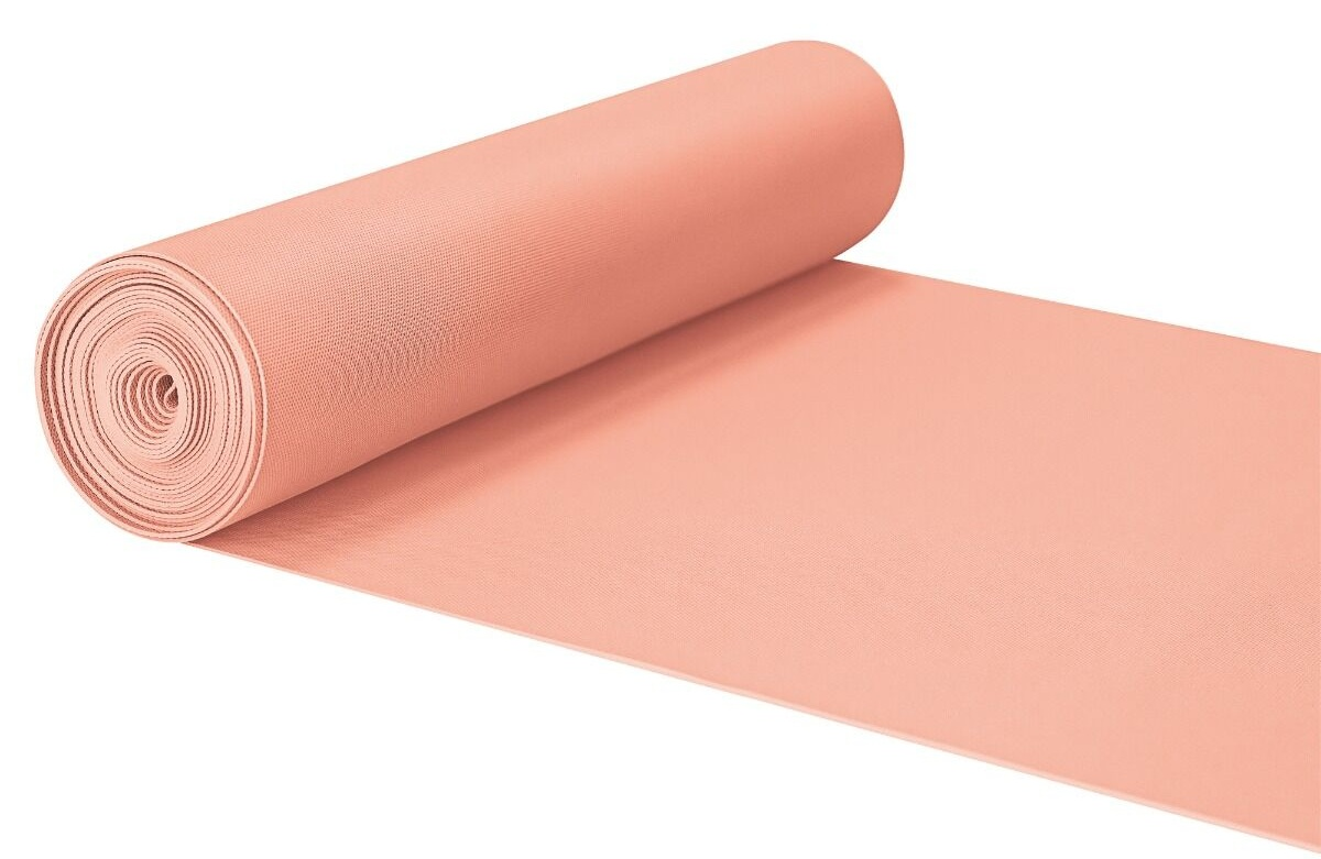 Zwinięta brzoskwiniowa mata i rozwinięta sekcja na białym tle. Mata ma teksturowaną powierzchnię.