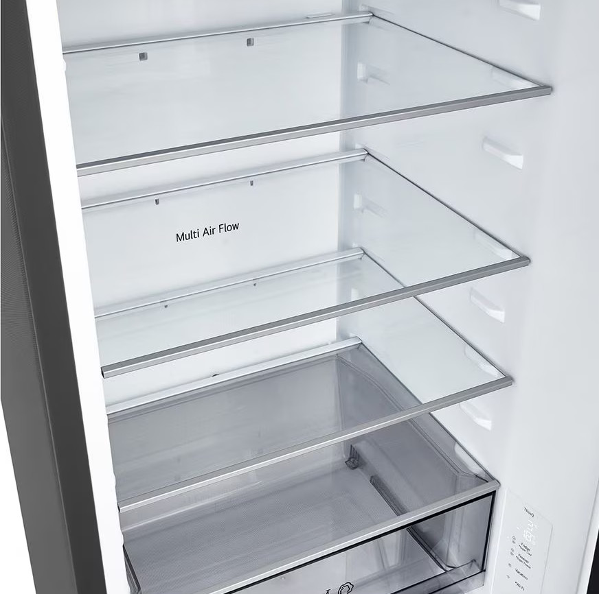 Wnętrze lodówki. Szklane półki ze srebrnymi obramowaniami i szuflada na dole. Widoczny napis 'Multi Air Flow'.