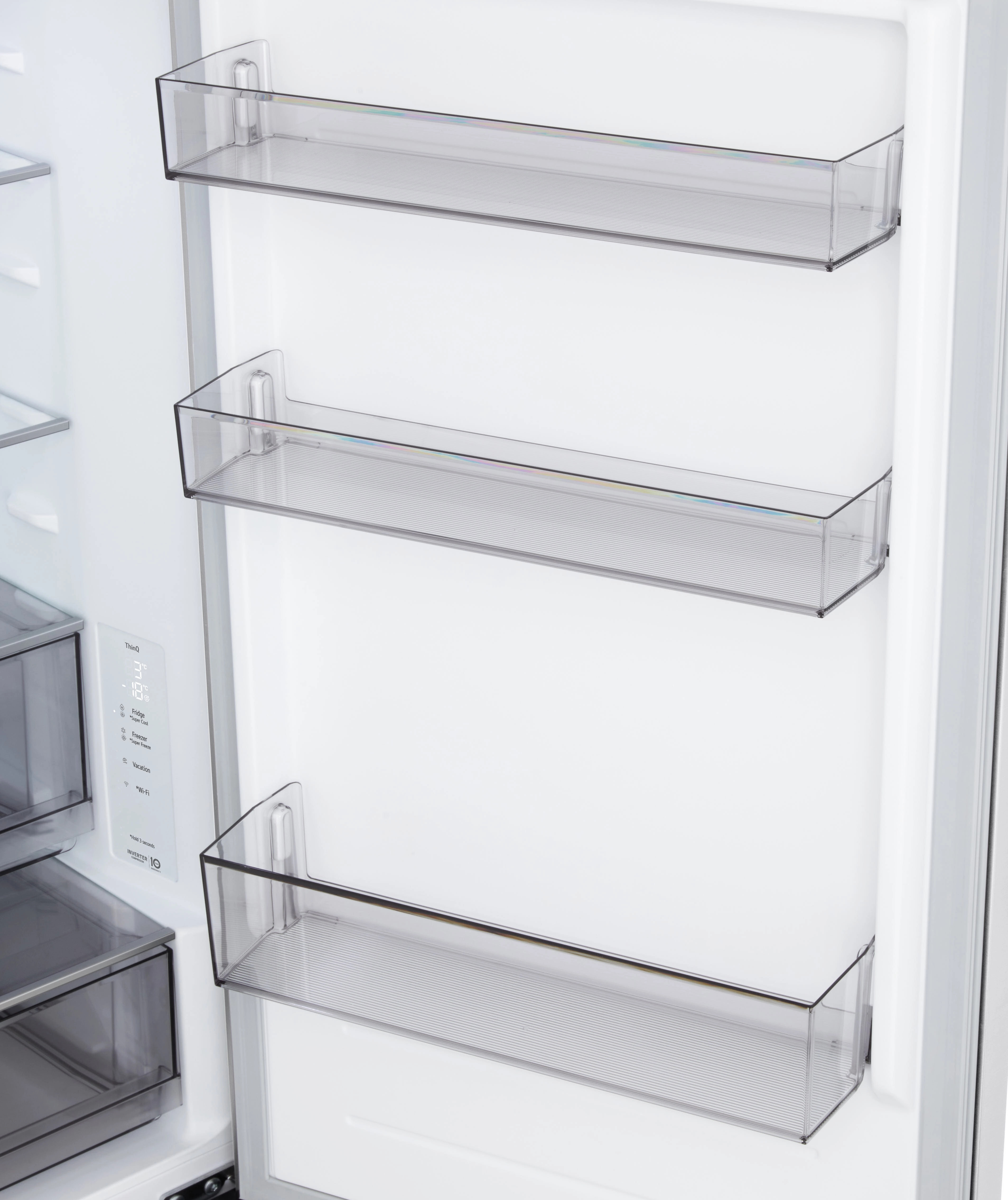 Otwarty wnętrze lodówki z przezroczystymi plastikowymi półkami. Po lewej stronie wyświetlacz cyfrowy z ustawieniami temperatury.