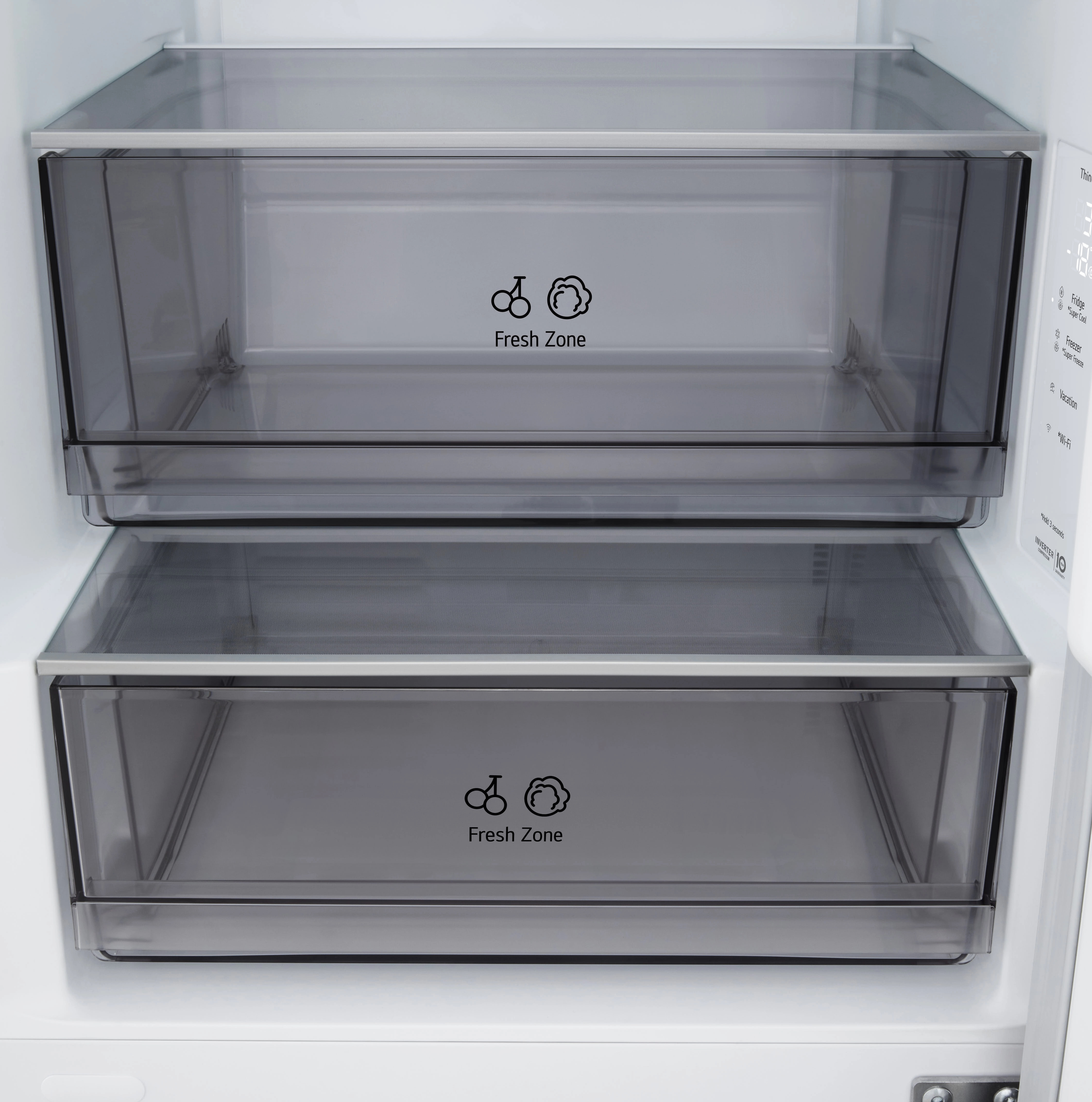 Otwarte drzwi lodówki z dwiema przezroczystymi szufladami z napisem 'Fresh Zone'. Białe wnętrze z panelem sterowania po prawej.