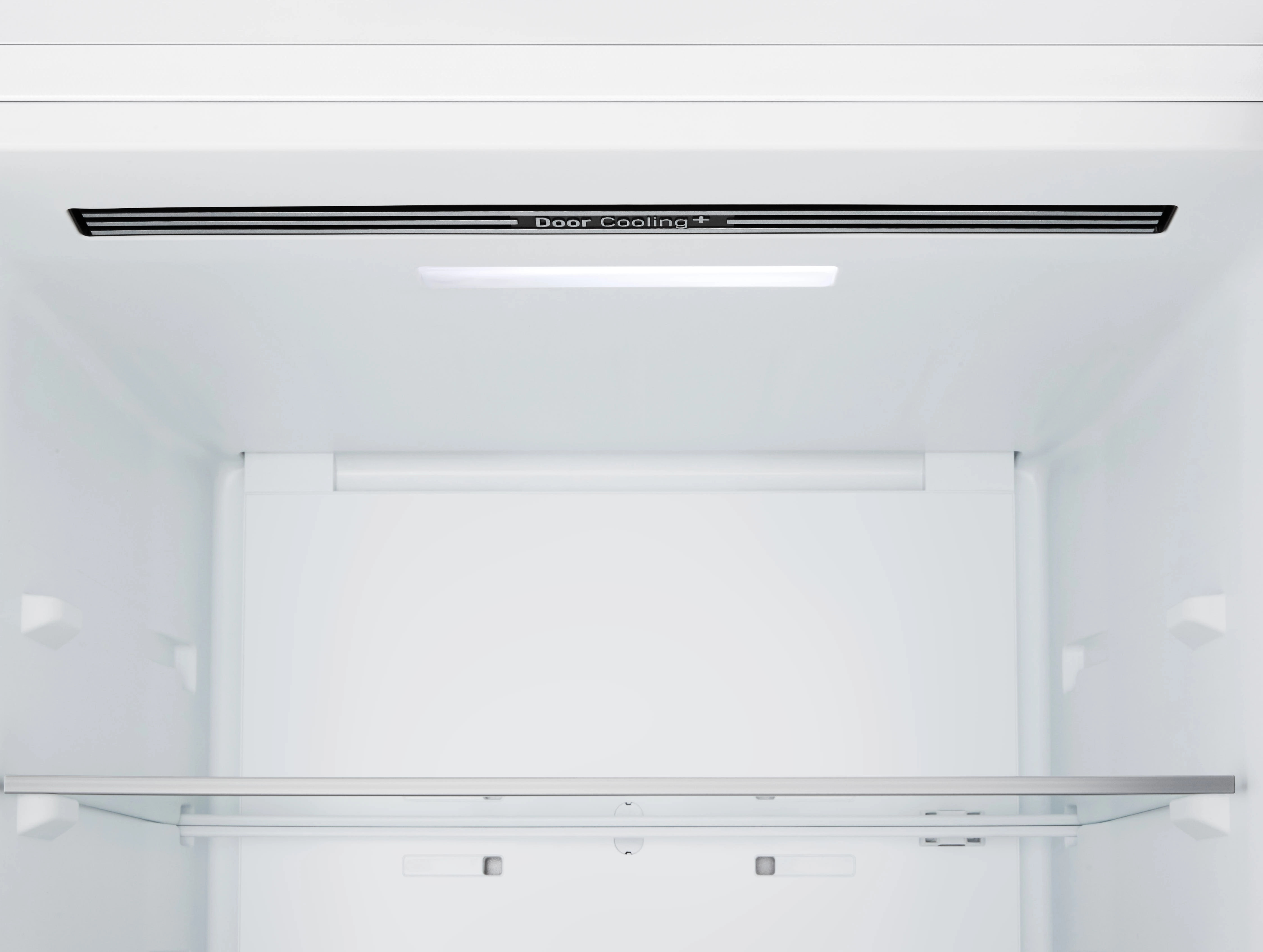 Wnętrze białej lodówki. Widoczna półka i wentylacja Door Cooling +.