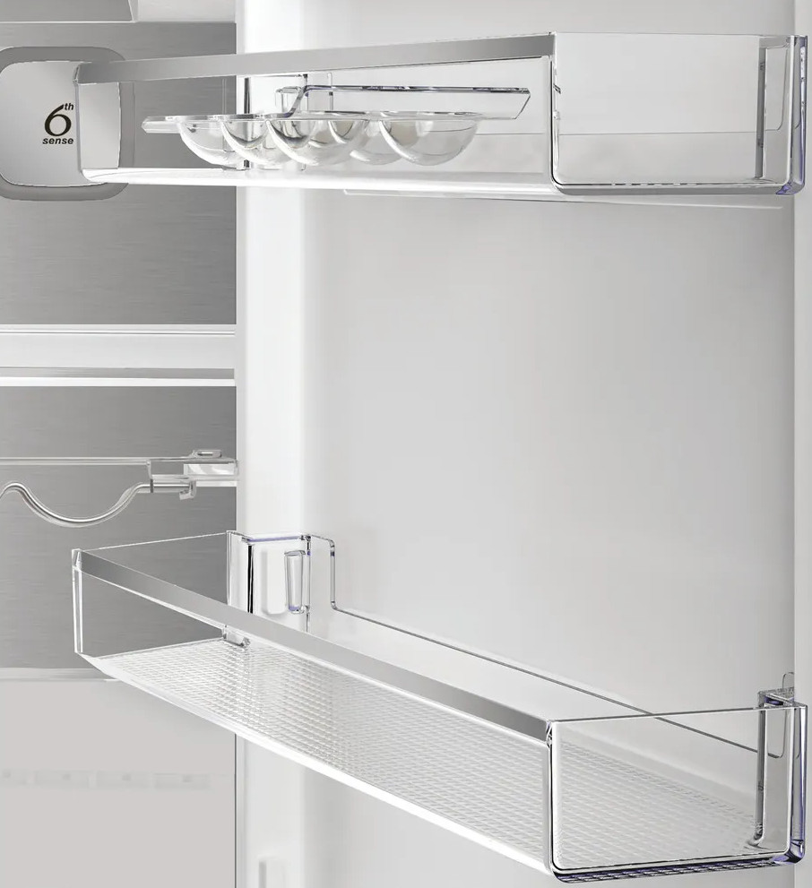 Wnętrze lodówki. Przezroczyste półki z pojemnikami na jajka. Widoczne logo '6th sense'. Białe wnętrze.