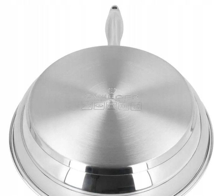 Błyszcząca patelnia ze stali nierdzewnej, widok od dołu, z uchwytem. Marka 'ZWIEGER' jest widoczna.