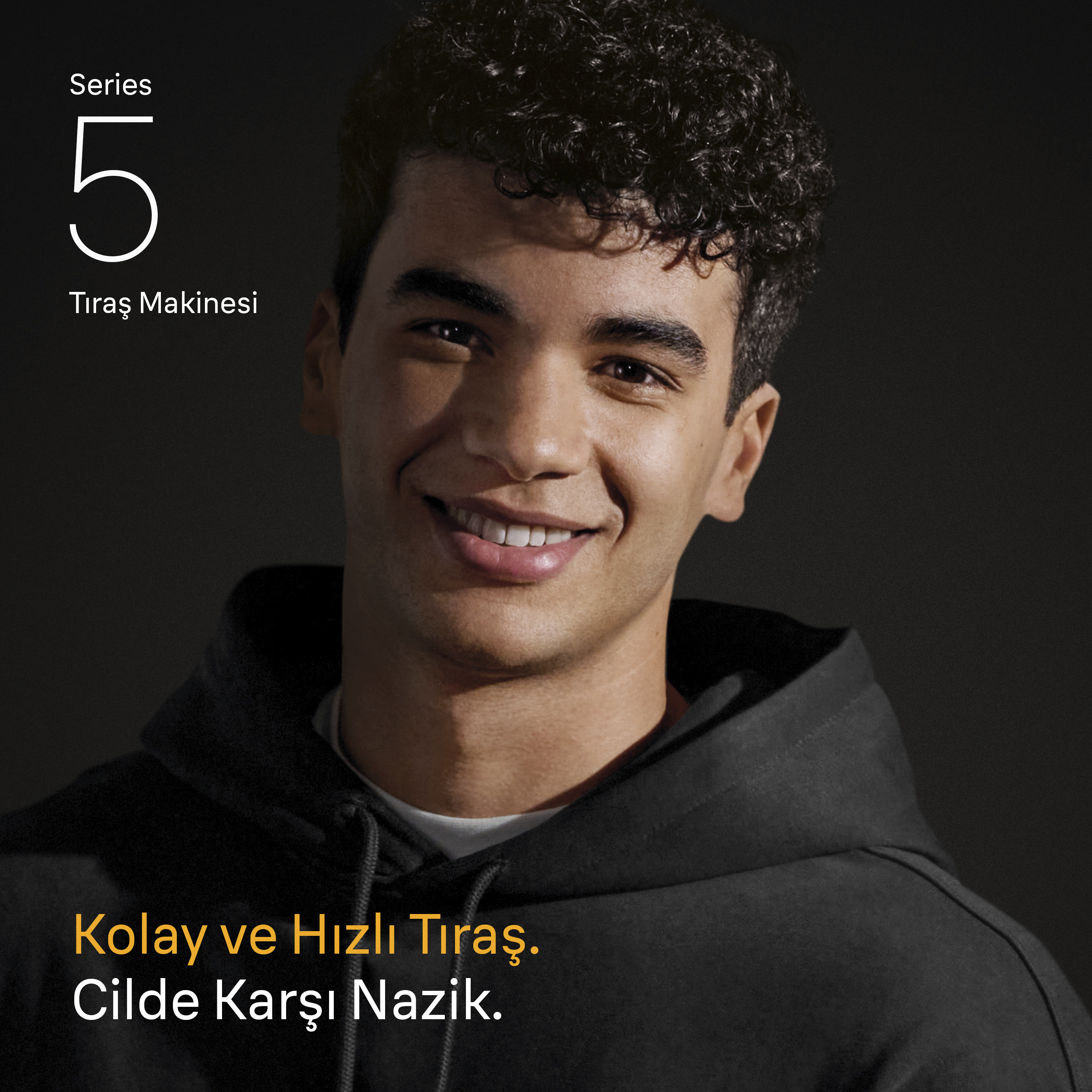 Siyah kapüşonlu bir tişört giymiş gülen bir adam. Metin: Seri 5, Tıraş Makinesi. Metin: Kolay ve Hızlı Tıraş. Cilde Karşı Nazik.