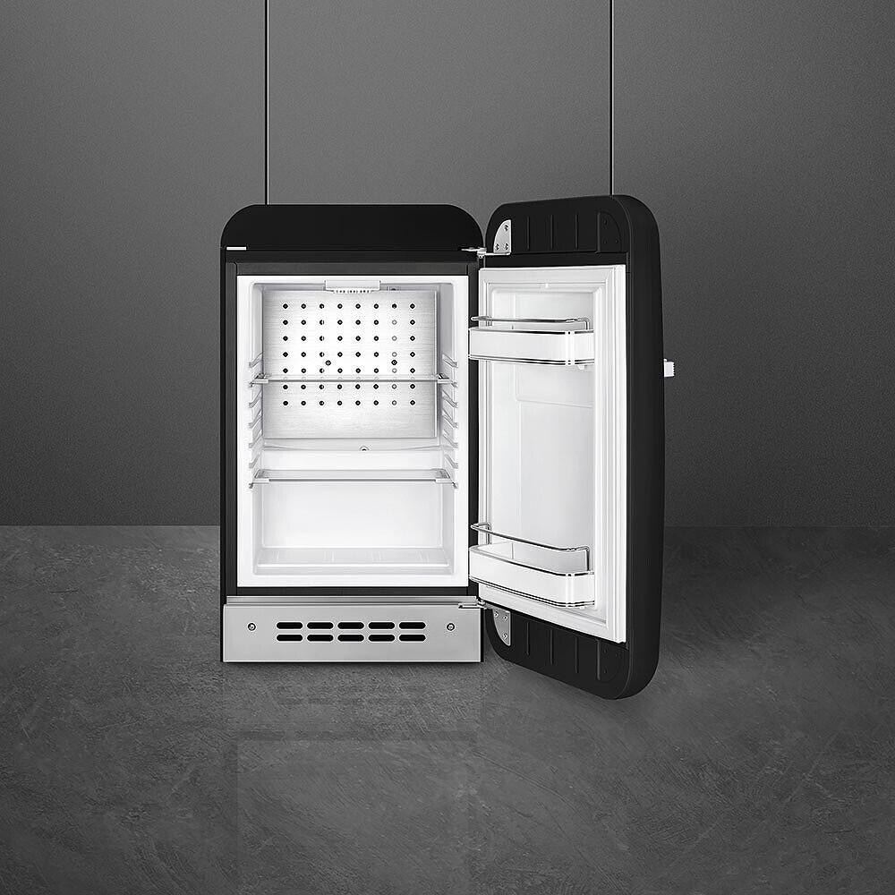 Offener schwarzer Kühlschrank. Weißer Innenraum mit Regalen, Tür angelehnt. Dunkelgrauer Hintergrund und Boden. Minimalistisches Design.