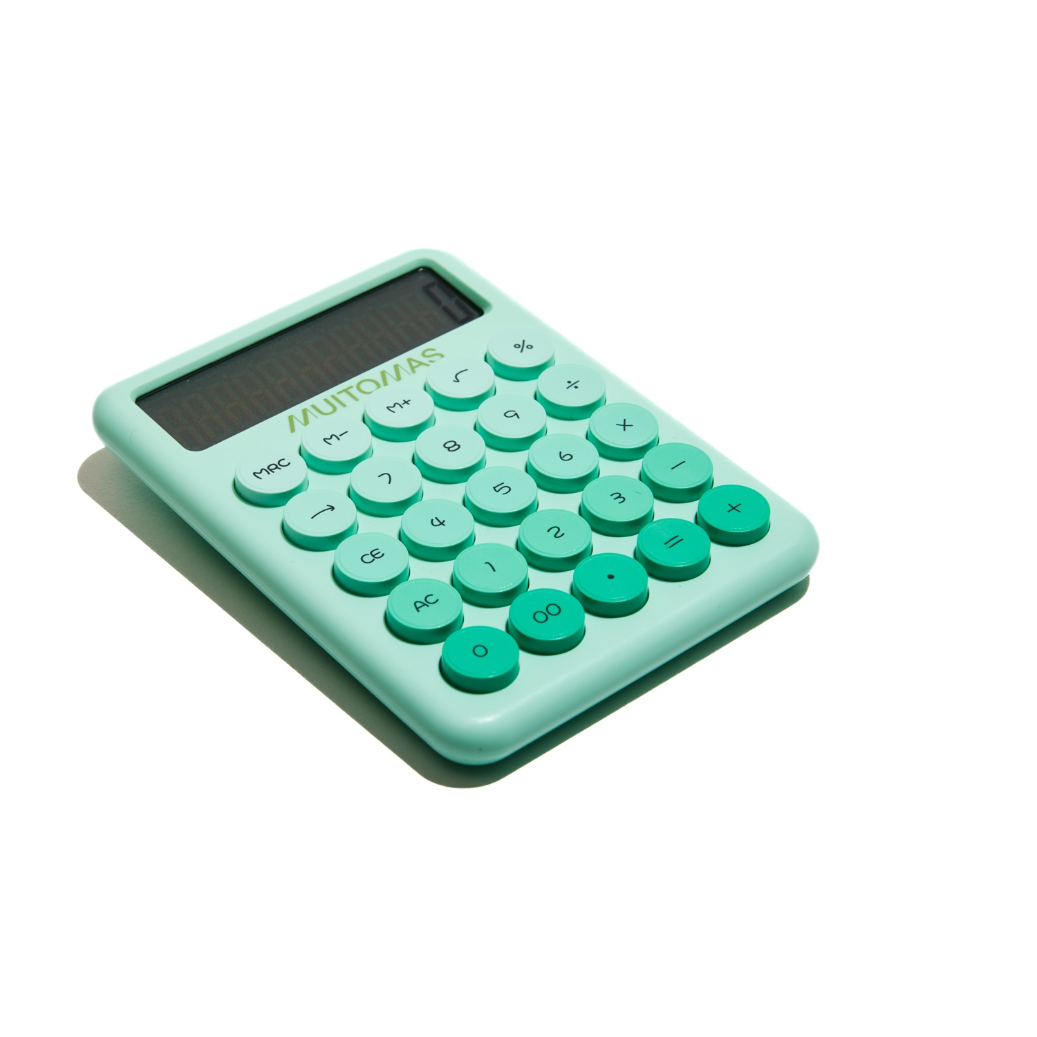 Una calcolatrice verde menta su una superficie bianca. Ha pulsanti rotondi e un display digitale. Il marchio è MUITOMAS.