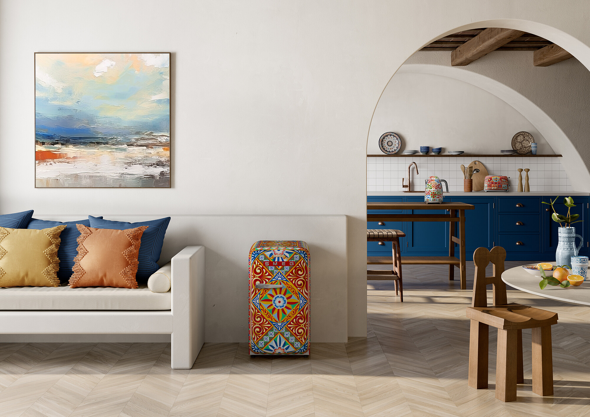 Wohnzimmer mit Sofa, bunten Kissen und einem Smeg-Kühlschrank. Ein Torbogen führt in eine Küche mit blauen Schränken.