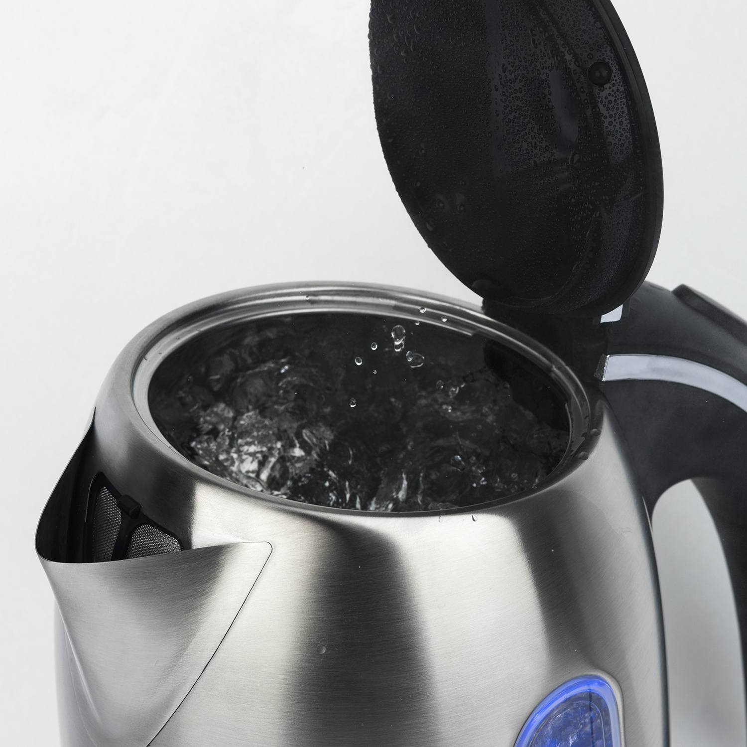 Un bollitore in acciaio inossidabile con acqua bollente all'interno e il coperchio aperto. Goccioline d'acqua sono visibili sul coperchio. Lo sfondo è bianco.