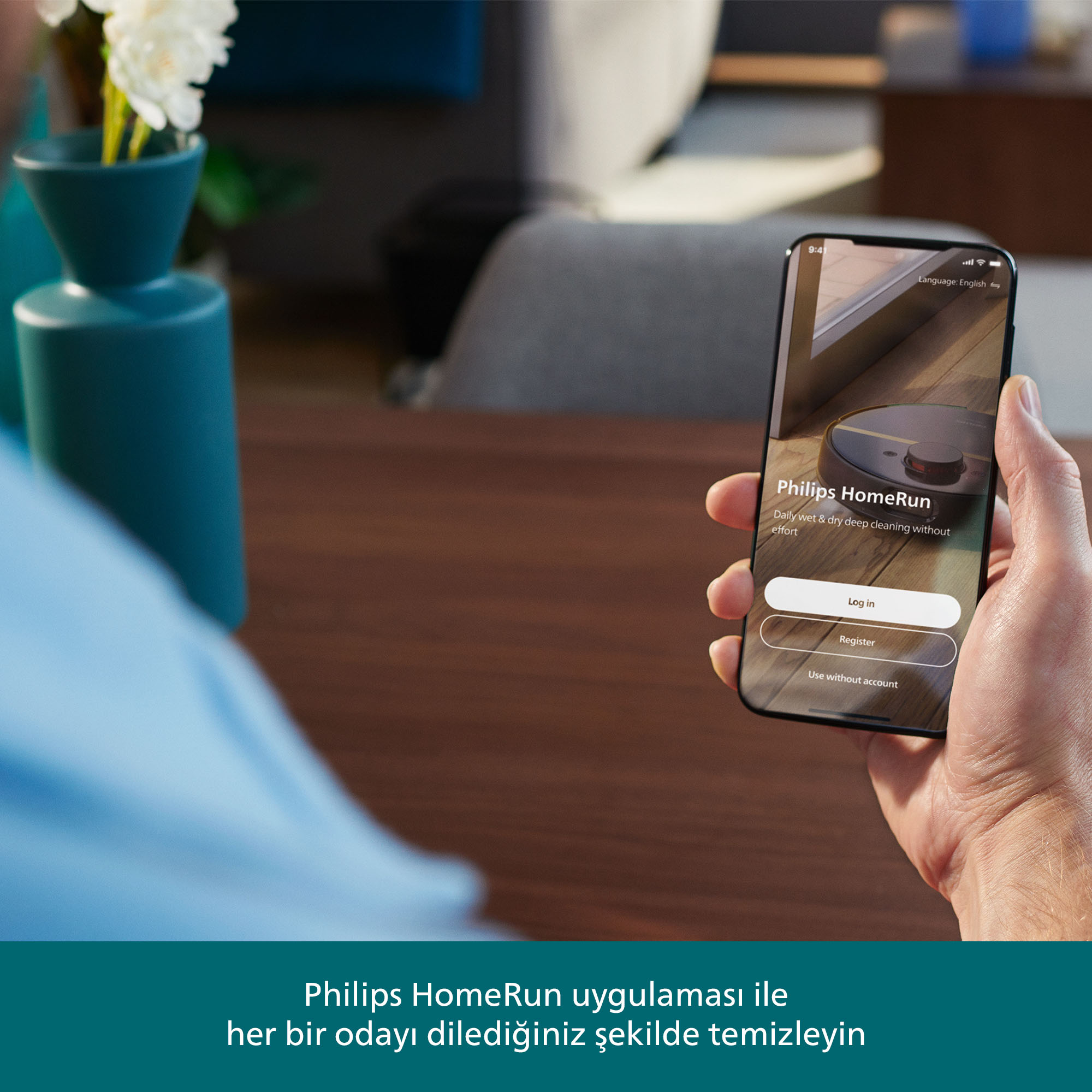 Bir el, Philips HomeRun uygulamasını gösteren bir telefon tutuyor. Ekranda bir elektrikli süpürge ve giriş seçenekleri var.