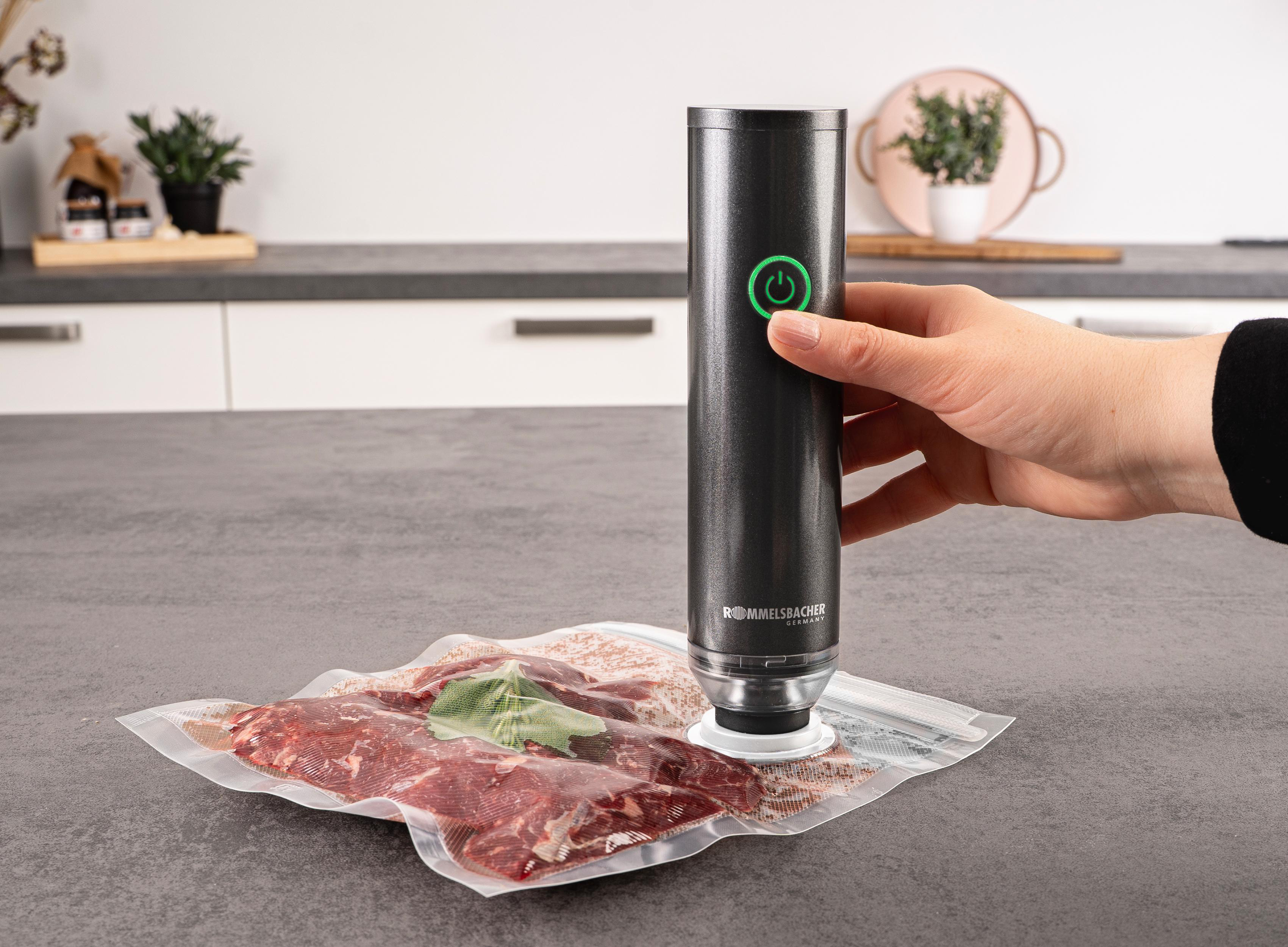 Eine Person vakuumiert rohes Fleisch mit einer Maschine. Der Hintergrund umfasst eine Küchentheke und dekorative Elemente.