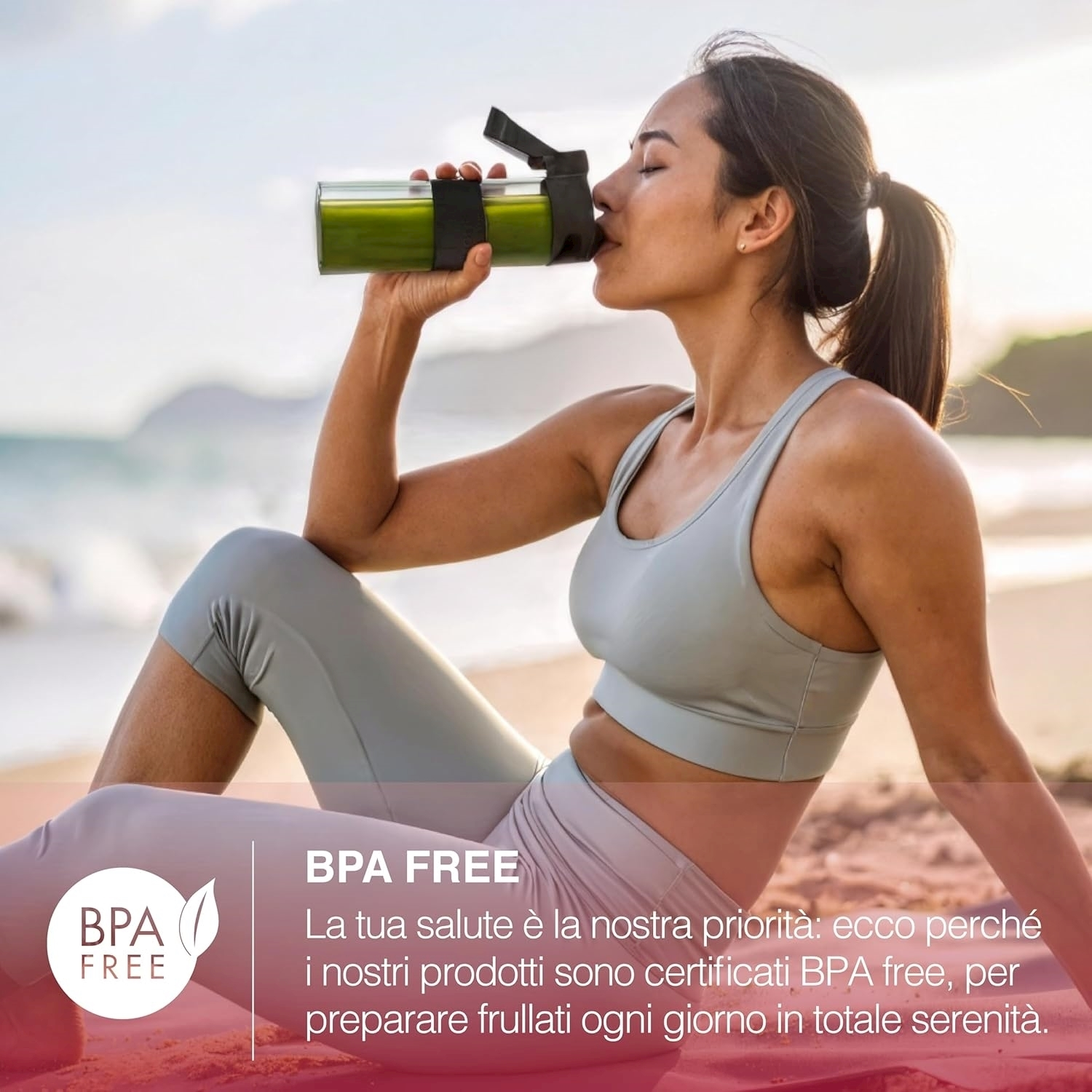Donna che beve da una bottiglia di frullato verde, seduta sulla spiaggia. Indossa abiti sportivi. Logo senza BPA in primo piano.