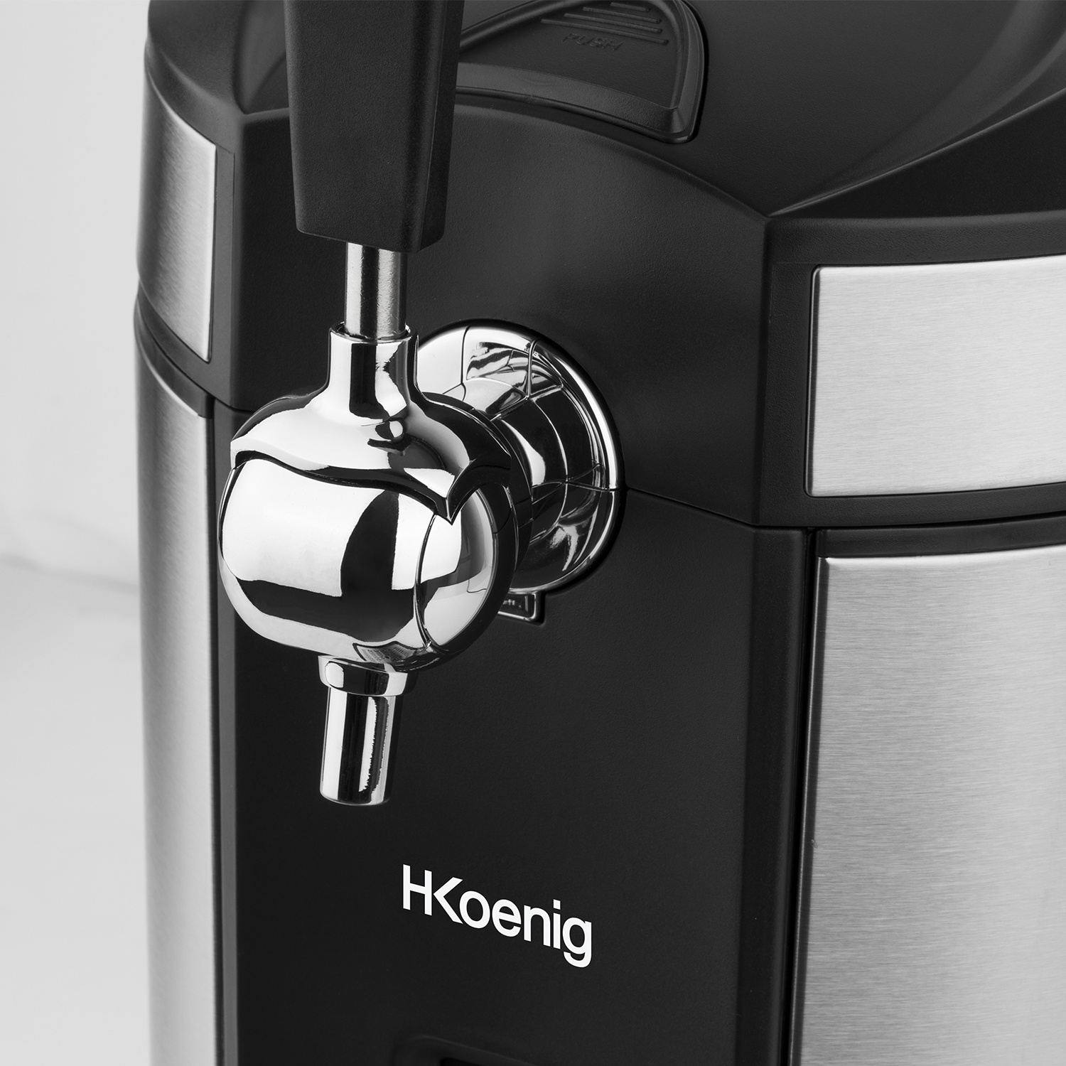Primo piano di un rubinetto della birra nero e argento. Il rubinetto è cromato, con il marchio 'HKoenig' visibile. Lo sfondo è sfocato.
