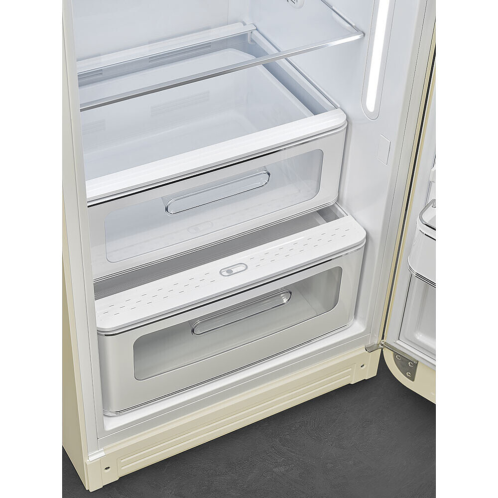 In einem Kühlschrank mit durchsichtigen Schubladen und Regalen. Die Tür ist geöffnet. Die Farbe ist Creme und Weiß.