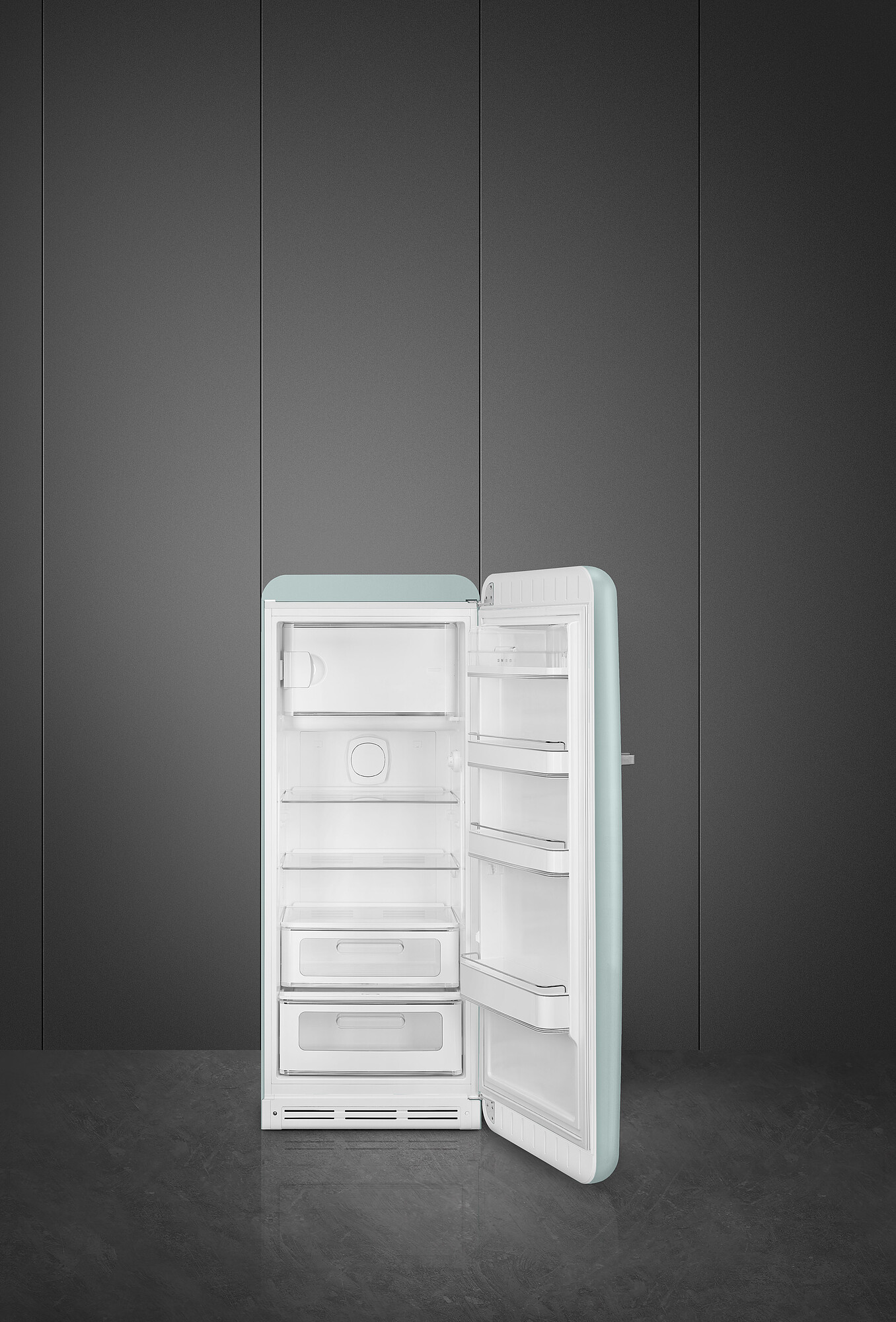 Ein offener Kühlschrank im Retro-Stil. Er ist mintgrün und weiß. Der Hintergrund ist eine dunkelgraue Wand und ein Boden. Die Tür ist offen.