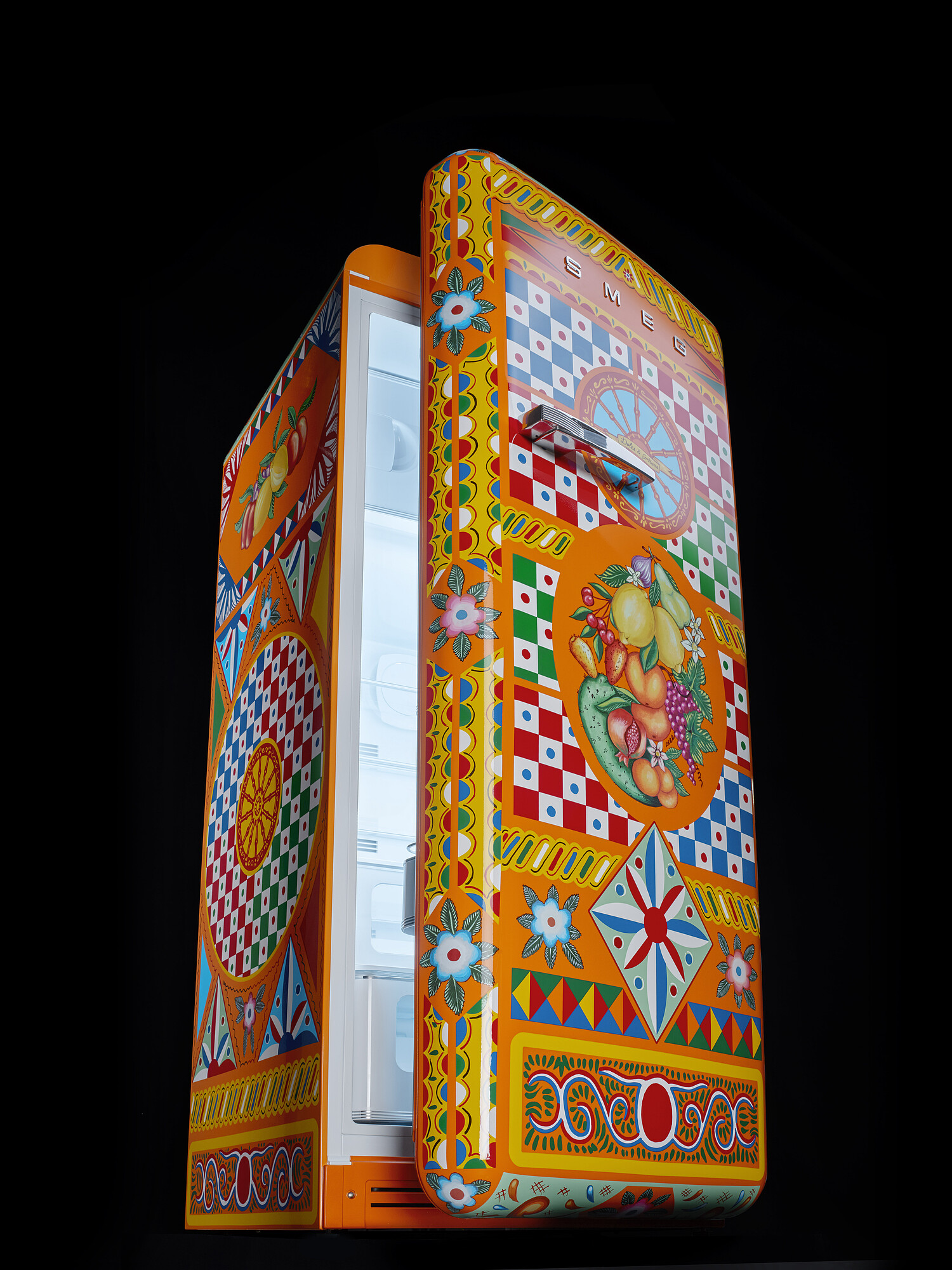 Ein bunter Smeg-Kühlschrank mit geöffneter Tür. Er hat Muster aus Früchten, Blumen und geometrischen Formen auf orangefarbenem Hintergrund.
