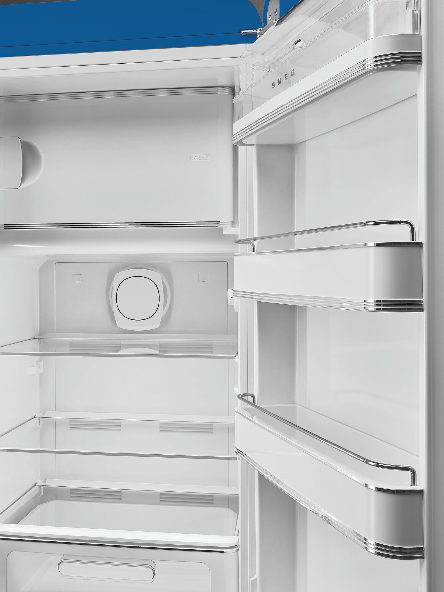 Offener weißer Kühlschrankinnenraum mit Regalen. Die Marke SMEG ist sichtbar. Die Tür ist offen und zeigt Regale und Fächer.
