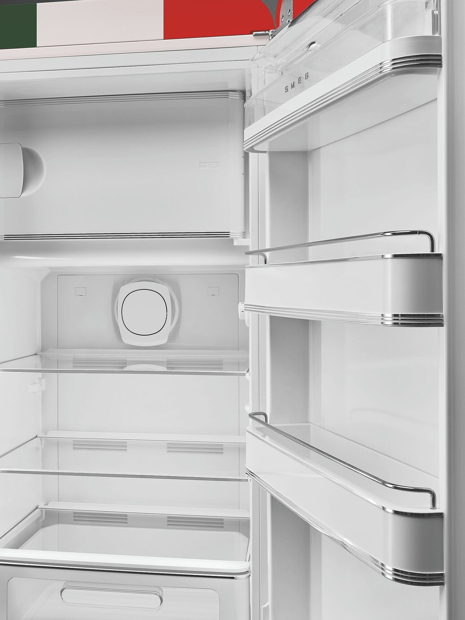Offener weißer SMEG-Kühlschrank. Innen leer, mit Glasböden und Chromakzenten. Italienische Flagge über dem Kühlschrank sichtbar.