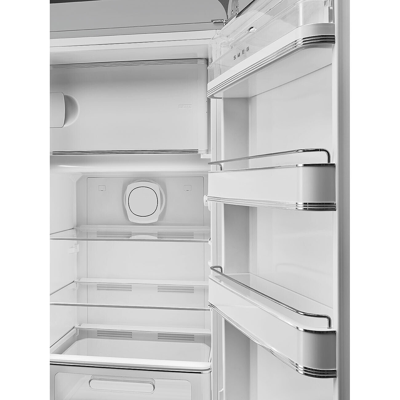 Offener weißer Kühlschrankinnenraum mit Regalen. Smeg-Logo sichtbar. Klare Regale. Weiße Tür mit Chromakzenten und Griff.