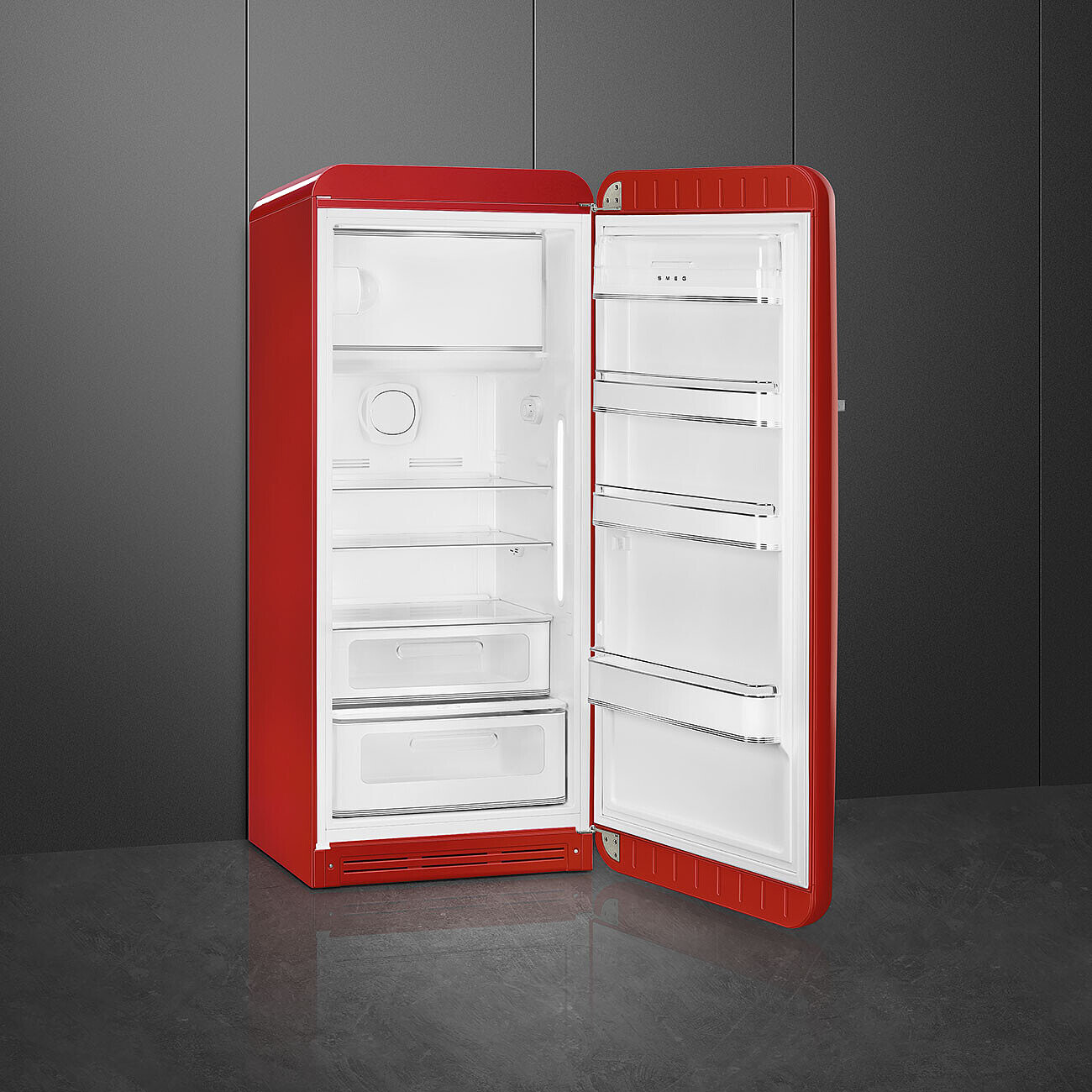 Ein roter Smeg-Kühlschrank mit geöffneter Tür. Der Innenraum ist weiß mit Regalen und Schubladen. Der Hintergrund ist grau.