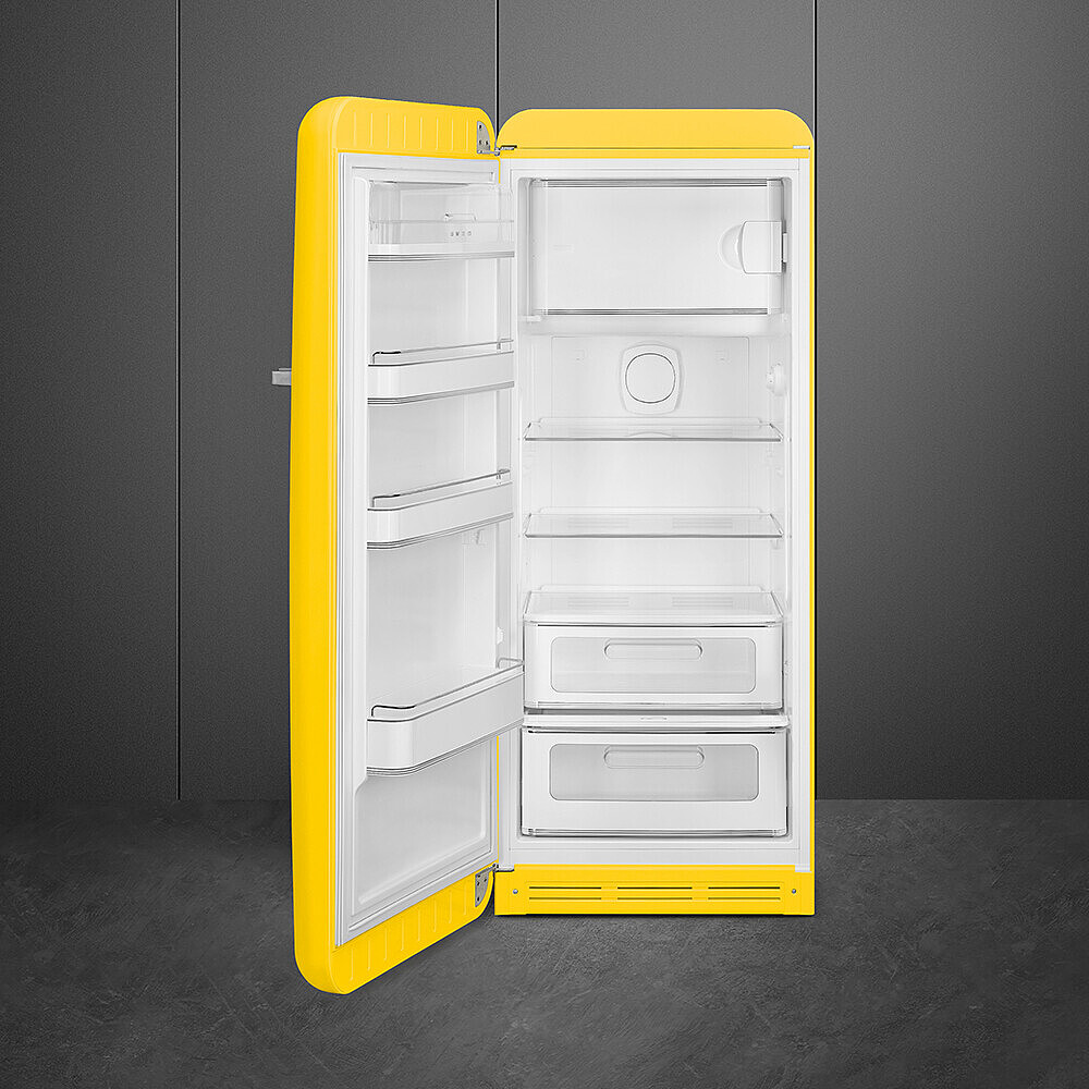 Ein gelber Retro-Kühlschrank mit geöffneter Tür, der weiße Regale und Schubladen zeigt. Der Hintergrund ist eine dunkelgraue Wand.