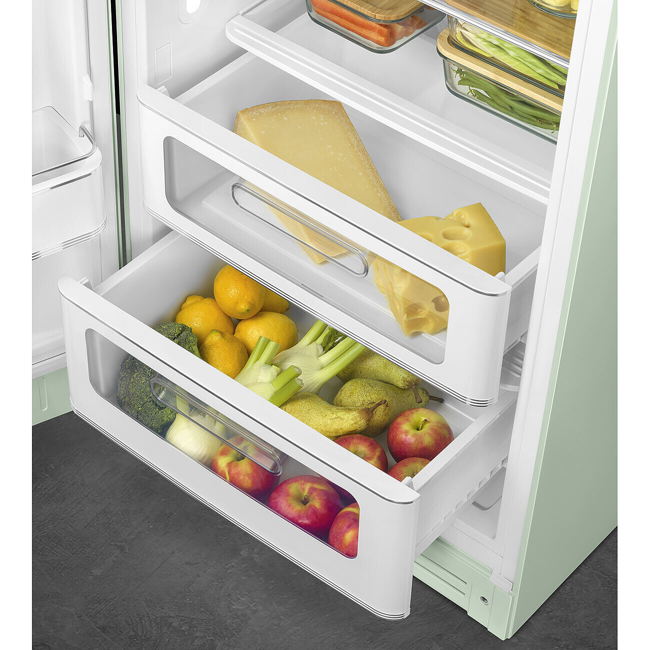 Im Kühlschrank befinden sich Schubladen mit Lebensmitteln: Käse, Zitronen, Brokkoli, Äpfel, Birnen und Fenchel. Der Kühlschrank ist hellgrün.