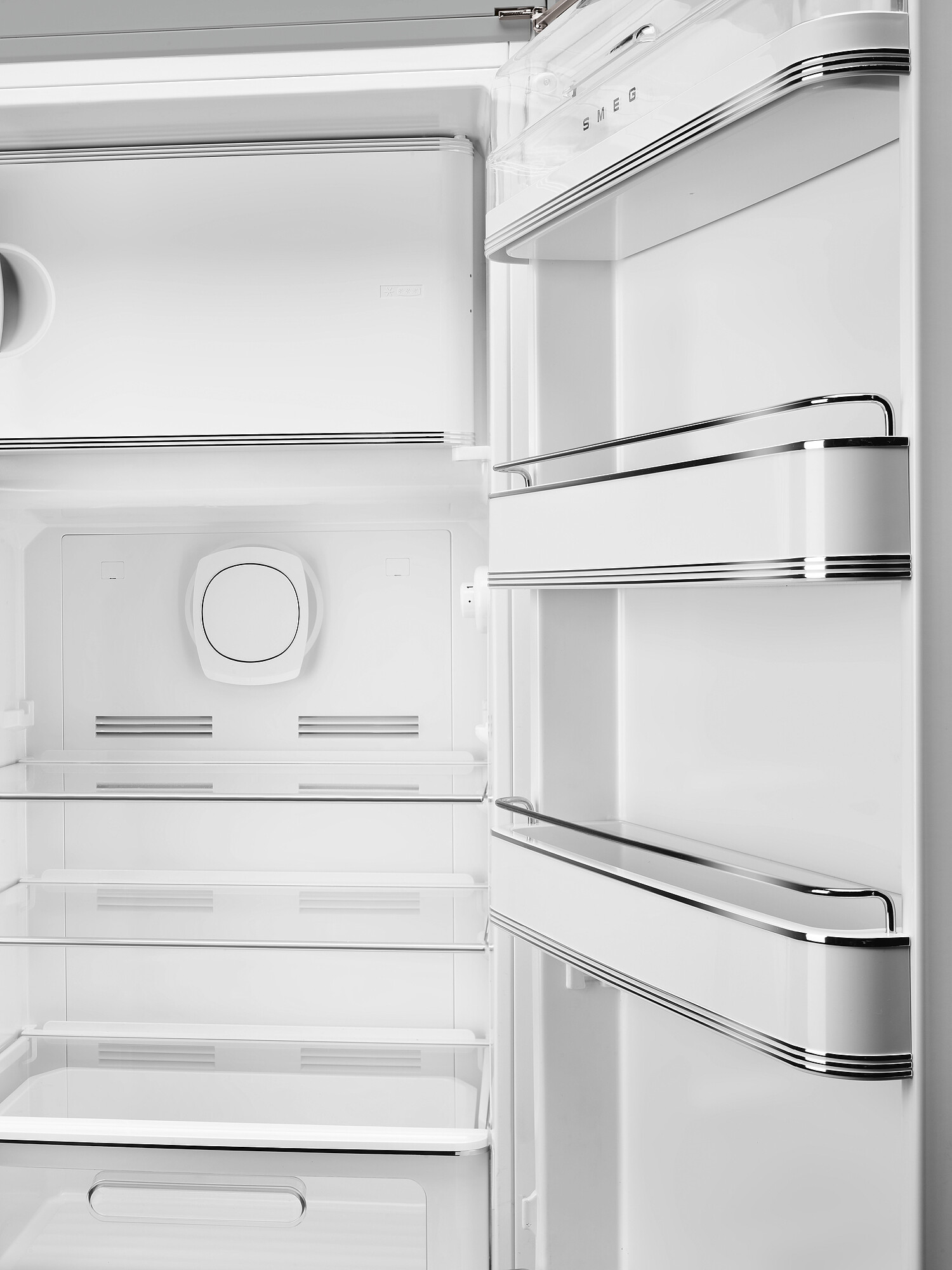 Offener weißer Smeg-Kühlschrankinnenraum. Regale und Fächer sind sichtbar. Die Tür ist geöffnet.