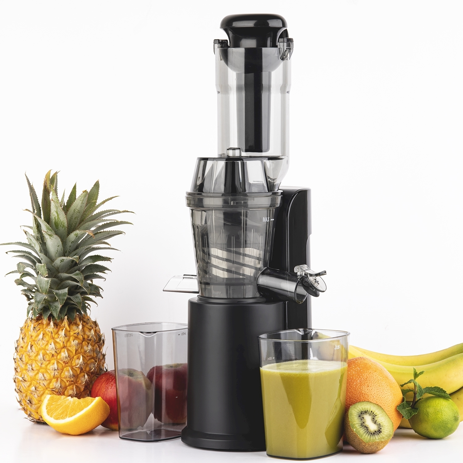 Un estrattore di succo nero con frutta come ananas, arance, mele, kiwi, banane e un bicchiere di succo su sfondo bianco.