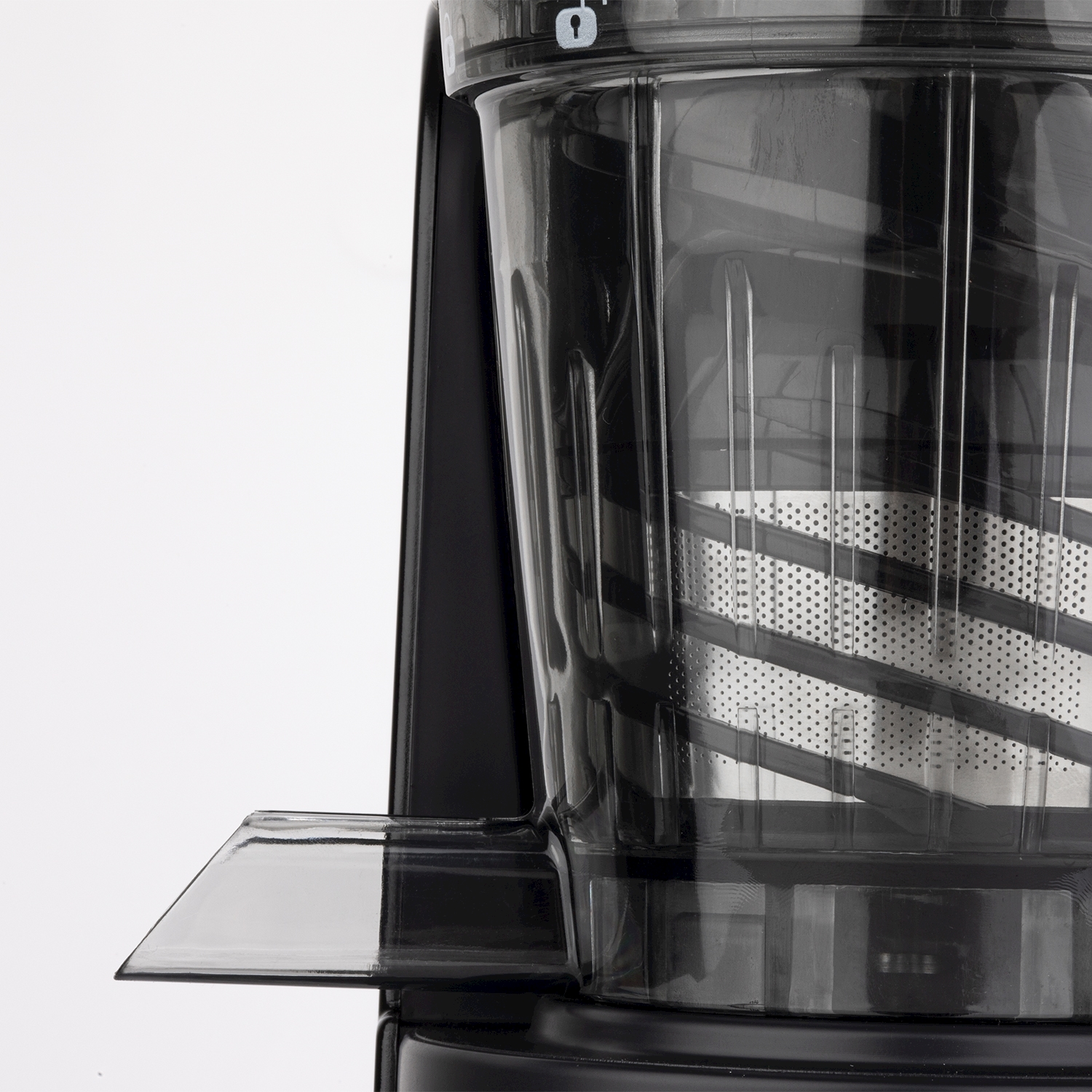 Primo piano di un componente nero di una centrifuga, contenitore trasparente con filtro in metallo perforato e beccuccio in plastica trasparente su sfondo bianco.