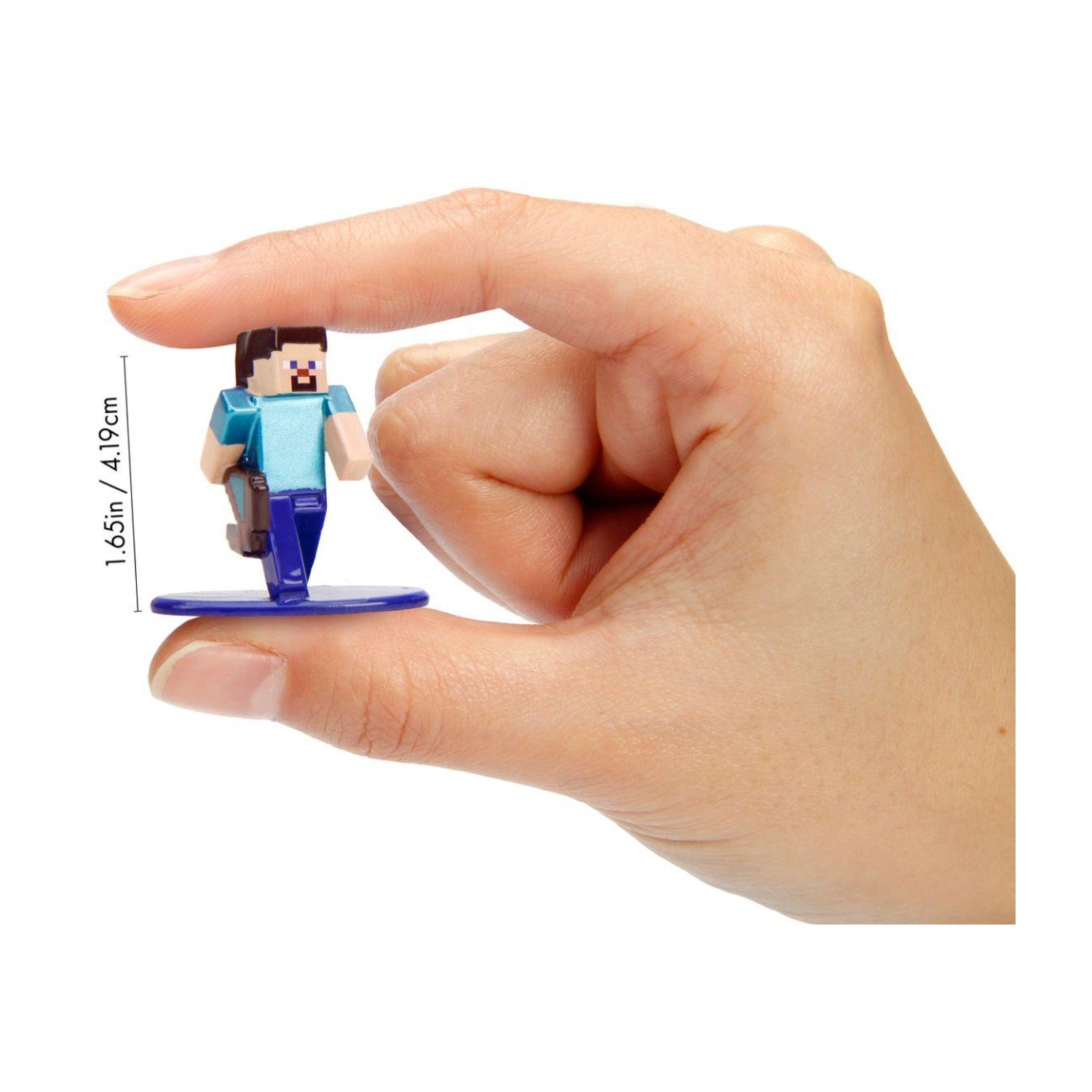 Una mano tiene una statuetta di Minecraft Steve, camicia blu, capelli scuri e pantaloni. Si erge su una base blu. Lo sfondo è bianco.