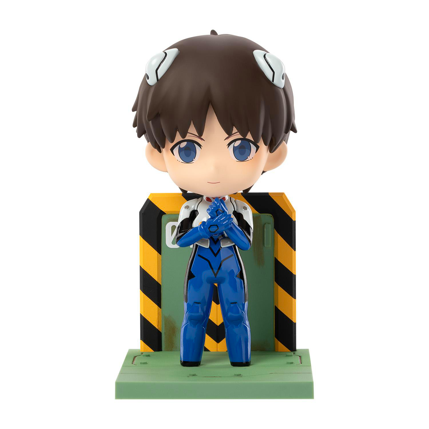Figur eines Anime-Charakters. Die Figur steht vor einer grünen Tür mit gelben und schwarzen Streifen.