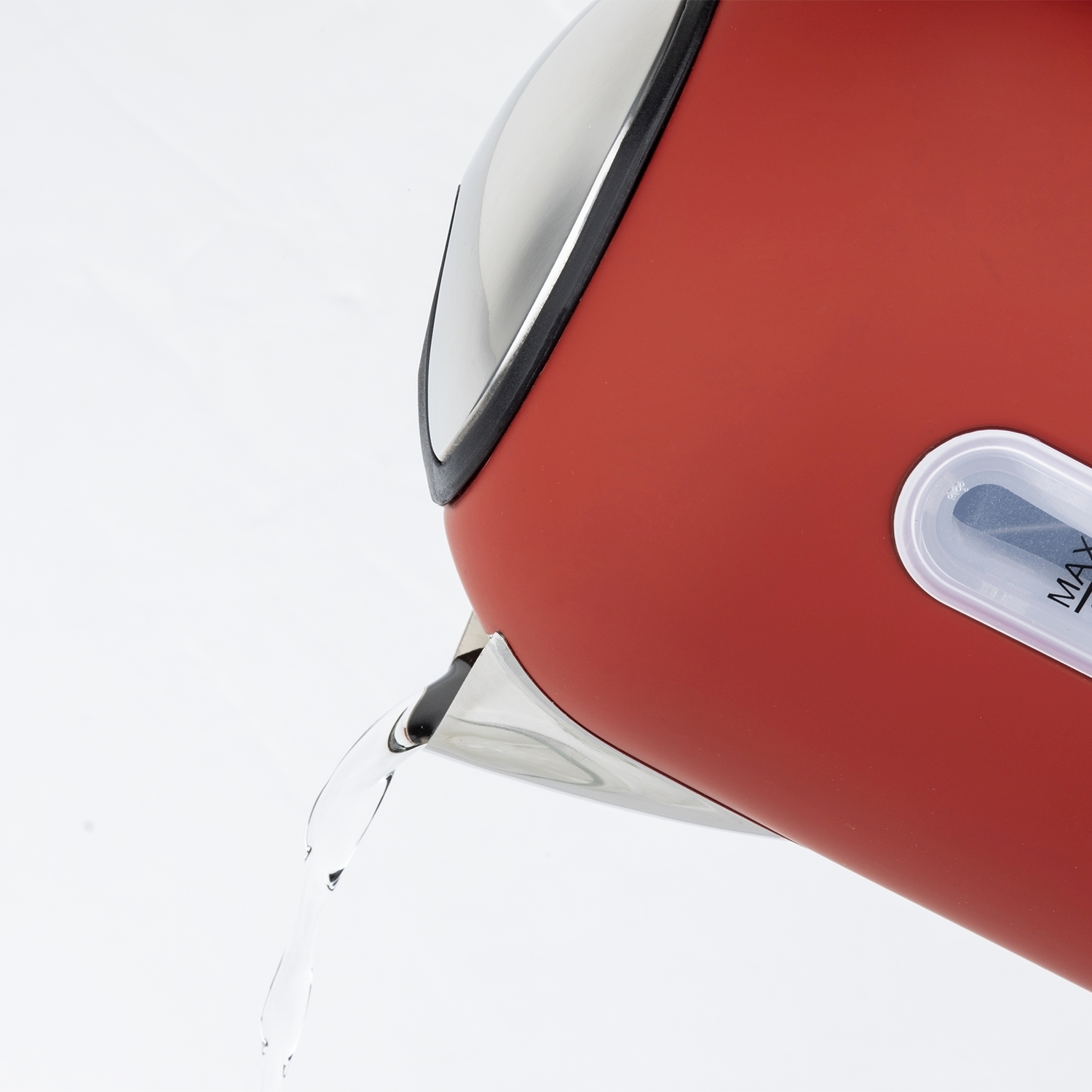 Un bollitore rosso versa acqua. Il beccuccio del bollitore è in acciaio inossidabile. Lo sfondo è bianco.