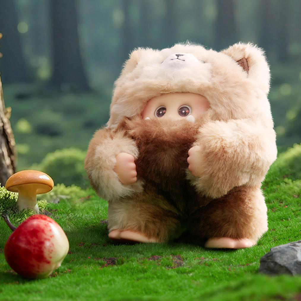 Eine Puppe in einem Bärenkostüm steht auf grünem Gras. Ein Pilz und ein roter Apfel sind vorne. Der Hintergrund zeigt einen verschwommenen Wald.