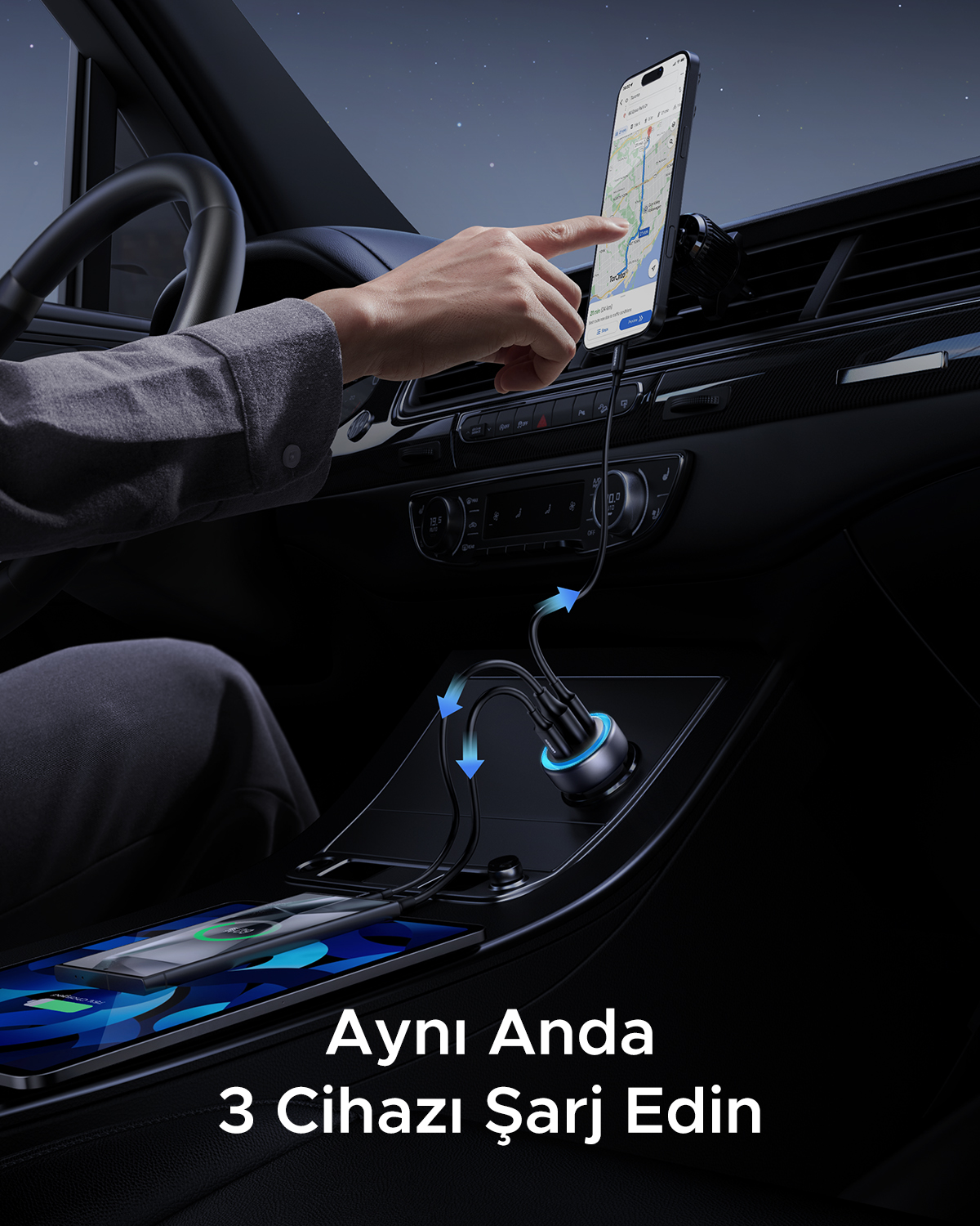 Bir arabanın içinde, bir el harita gösteren bir telefonla etkileşime giriyor, aynı anda bir tablet ve telefonu şarj ediyor. Metin: '3 Cihazı Şarj Et'.