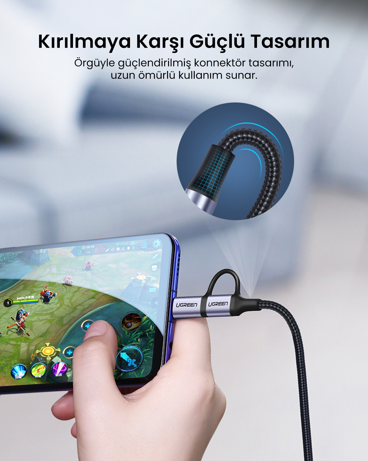Bir el, bir UGREEN kablosuna bağlı bir telefon tutuyor. Telefon bir oyun gösteriyor. Kablo güçlü bir tasarıma sahip.