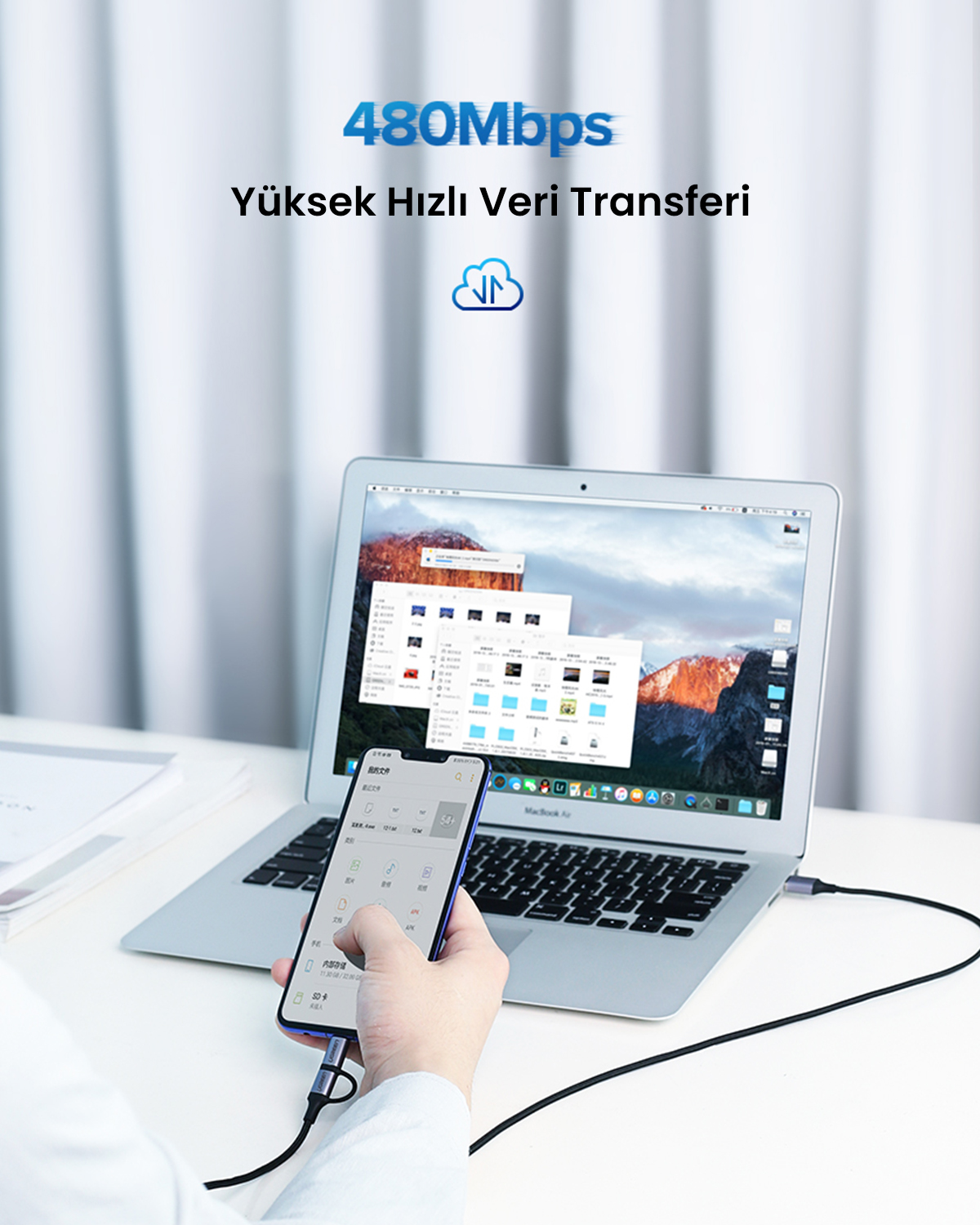 Bir kişi, bir kablo aracılığıyla bir dizüstü bilgisayara bağlı bir telefon tutuyor. Dizüstü bilgisayar bir dağ resmi görüntülüyor. Üstteki metin: 480Mbps, Yüksek Hızlı Veri Aktarımı.