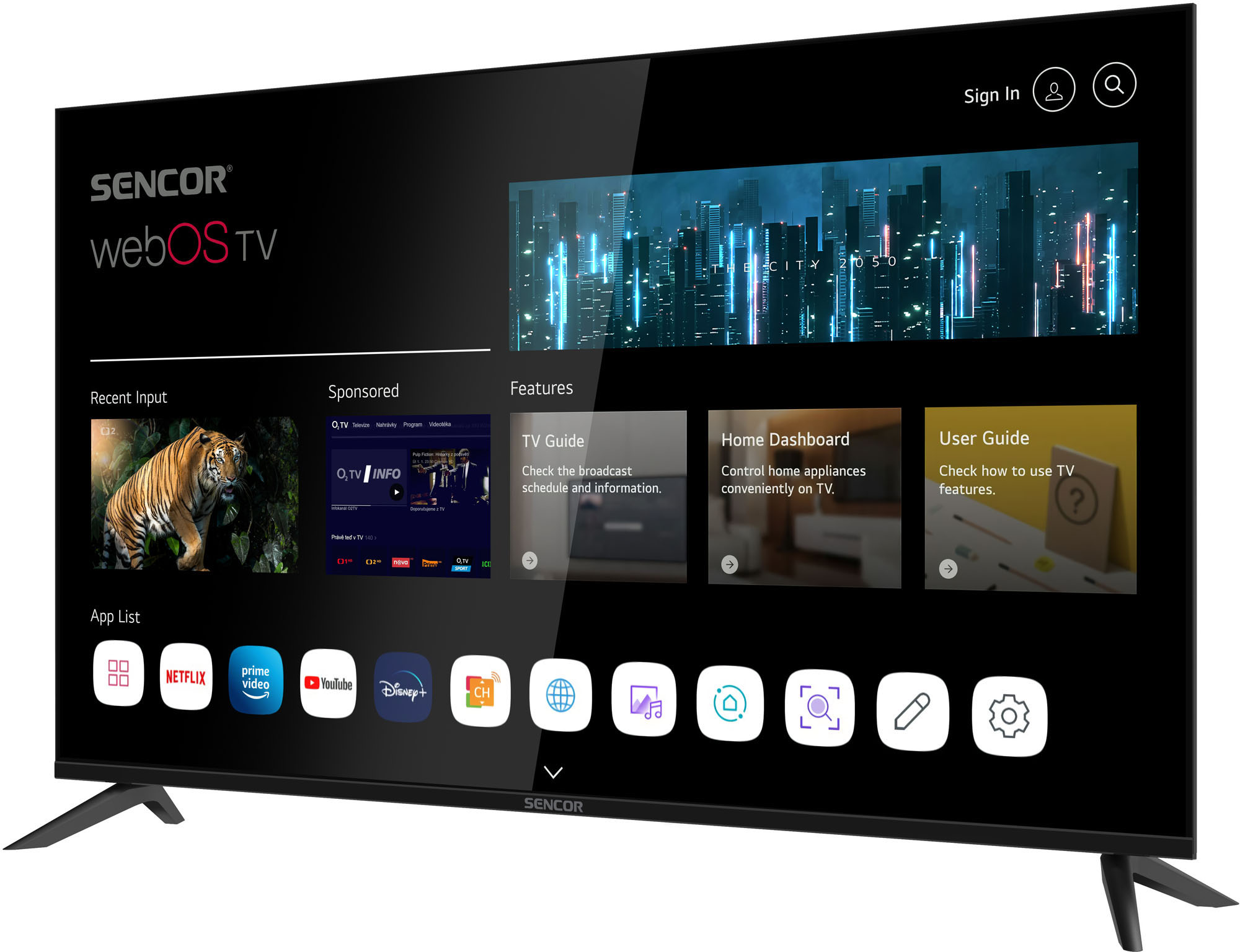 A Sencor webOS TV egy városi látképet mutat, alatta alkalmazásikonokkal. Egy tigris videó látható balra. A TV állványon van.