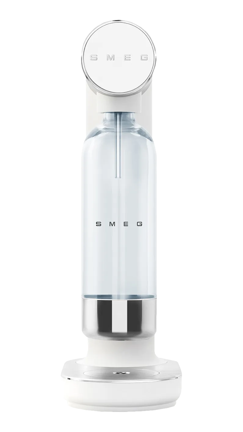 Un produttore di soda Smeg bianco. Ha una bottiglia trasparente e un top rotondo con il logo Smeg. La base è bianca e argentata.