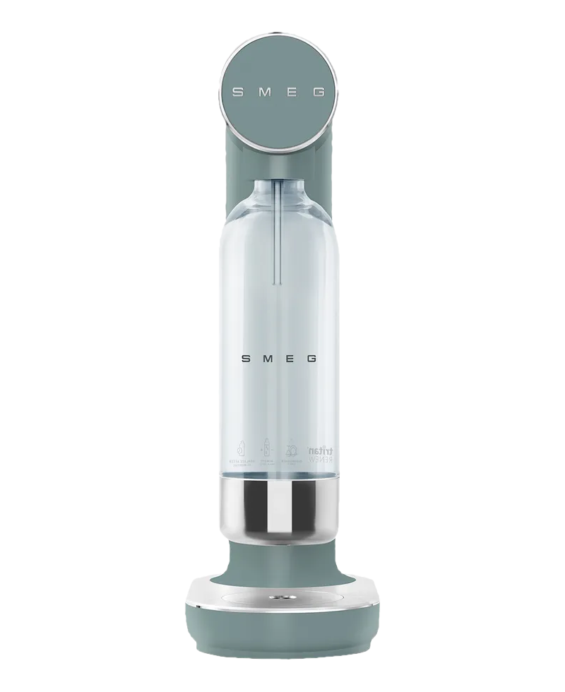 Un soda Smeg en sarcelle et argent, avec une bouteille transparente à l'intérieur. Le nom de la marque est visible.