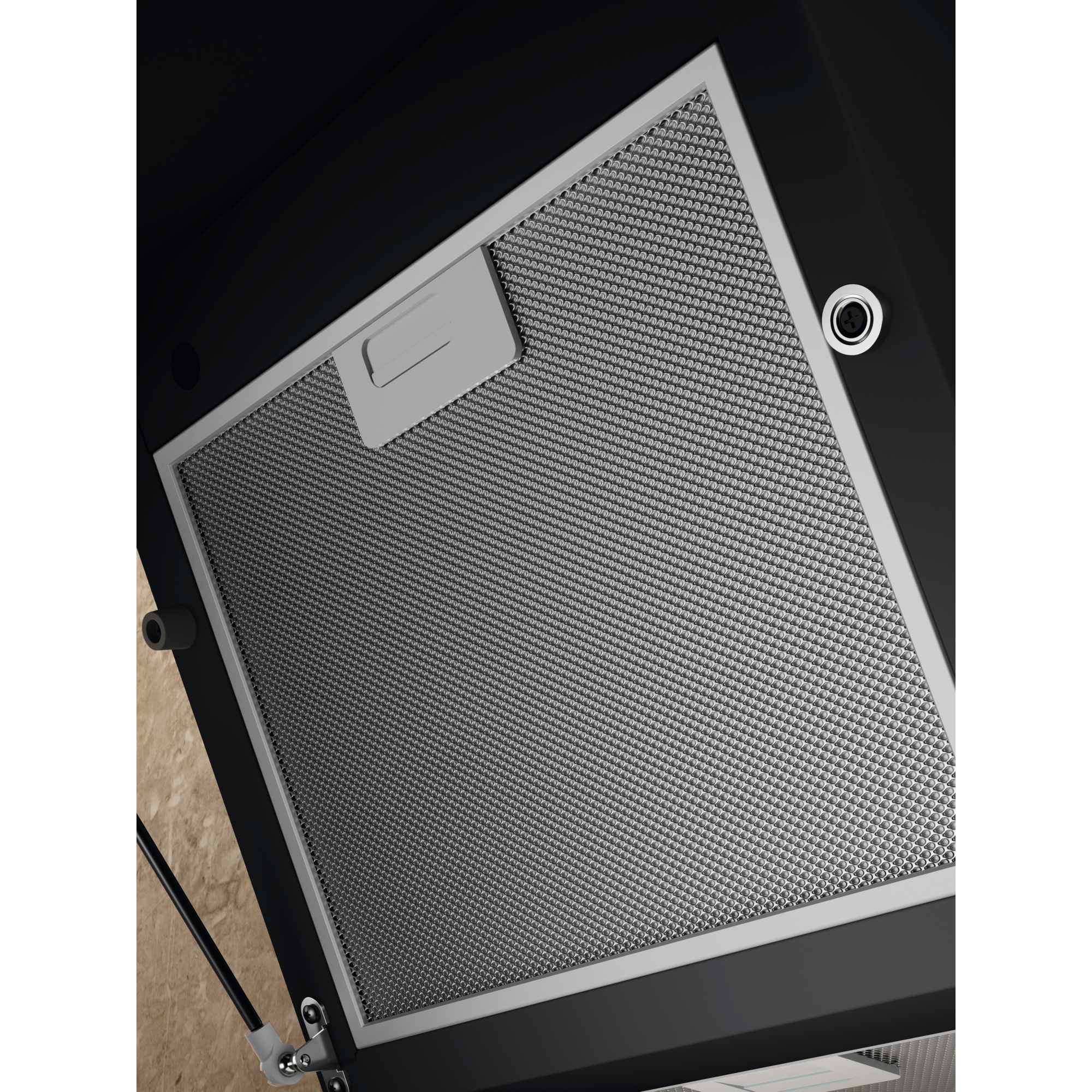 Zbliżenie filtra okapu kuchennego. Jest to metalowa siatka w białej ramie, na czarnym tle.