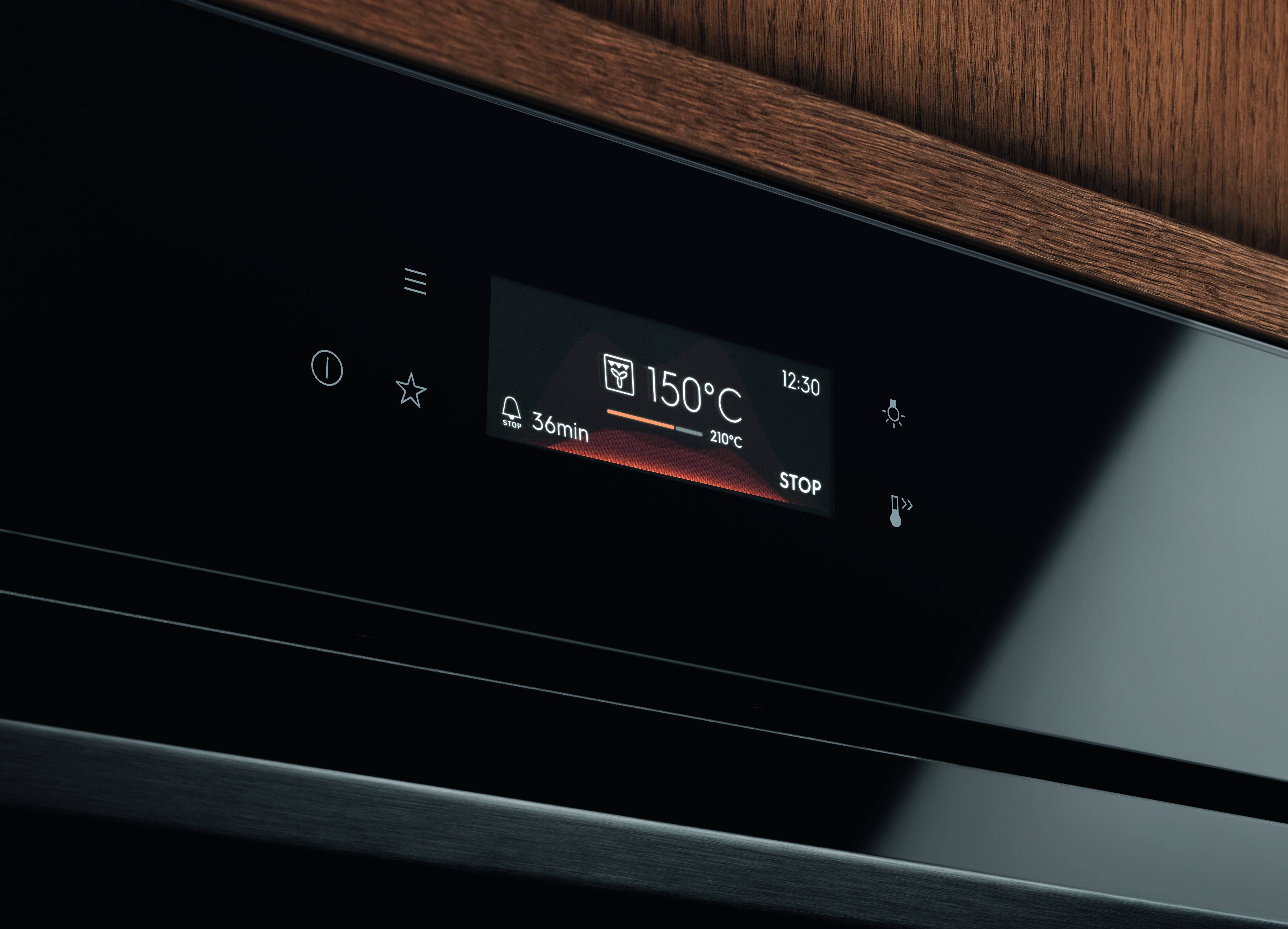 Zbliżenie panelu sterowania piekarnika. Wyświetlacz pokazuje 150°C, 36min i 12:30. Ikony to gwiazda, światło i przycisk stop.