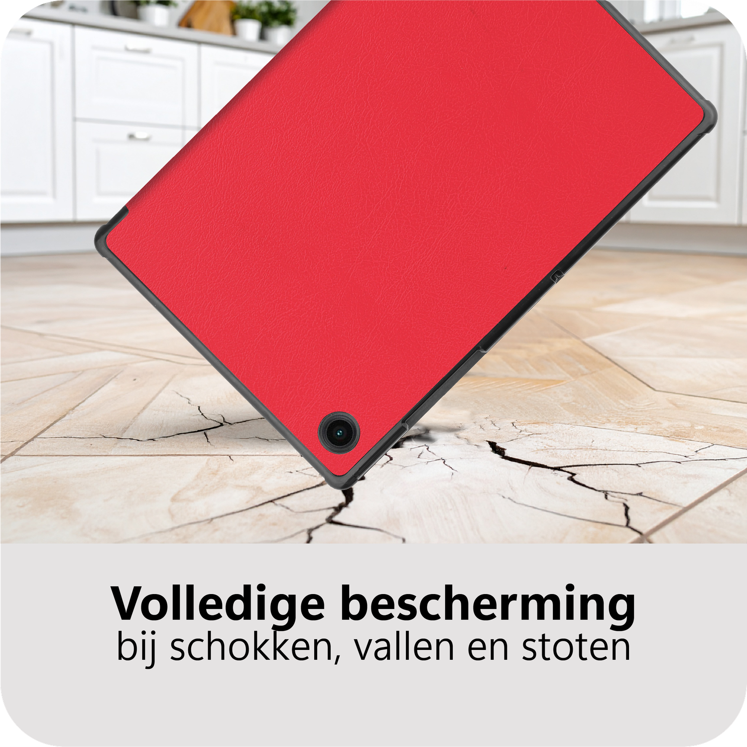 A red tablet case lies on a tiled floor. The case appears to be falling and cracking the floor. Background has white cabinets.