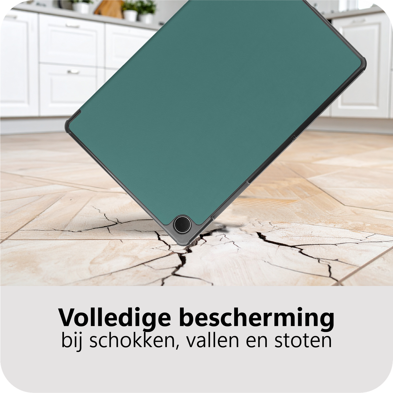 A tablet with a green cover is falling on a cracked tile floor. White cabinets are in the background.