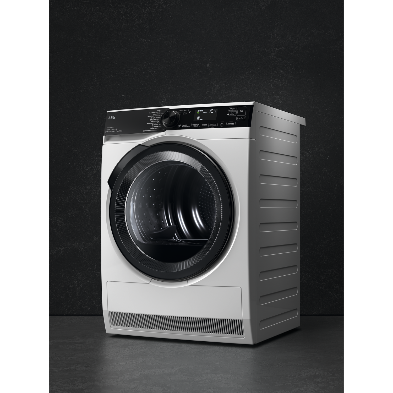 A white AEG dryer stands against a dark gray wall. It has a black door and control panel with digital display.