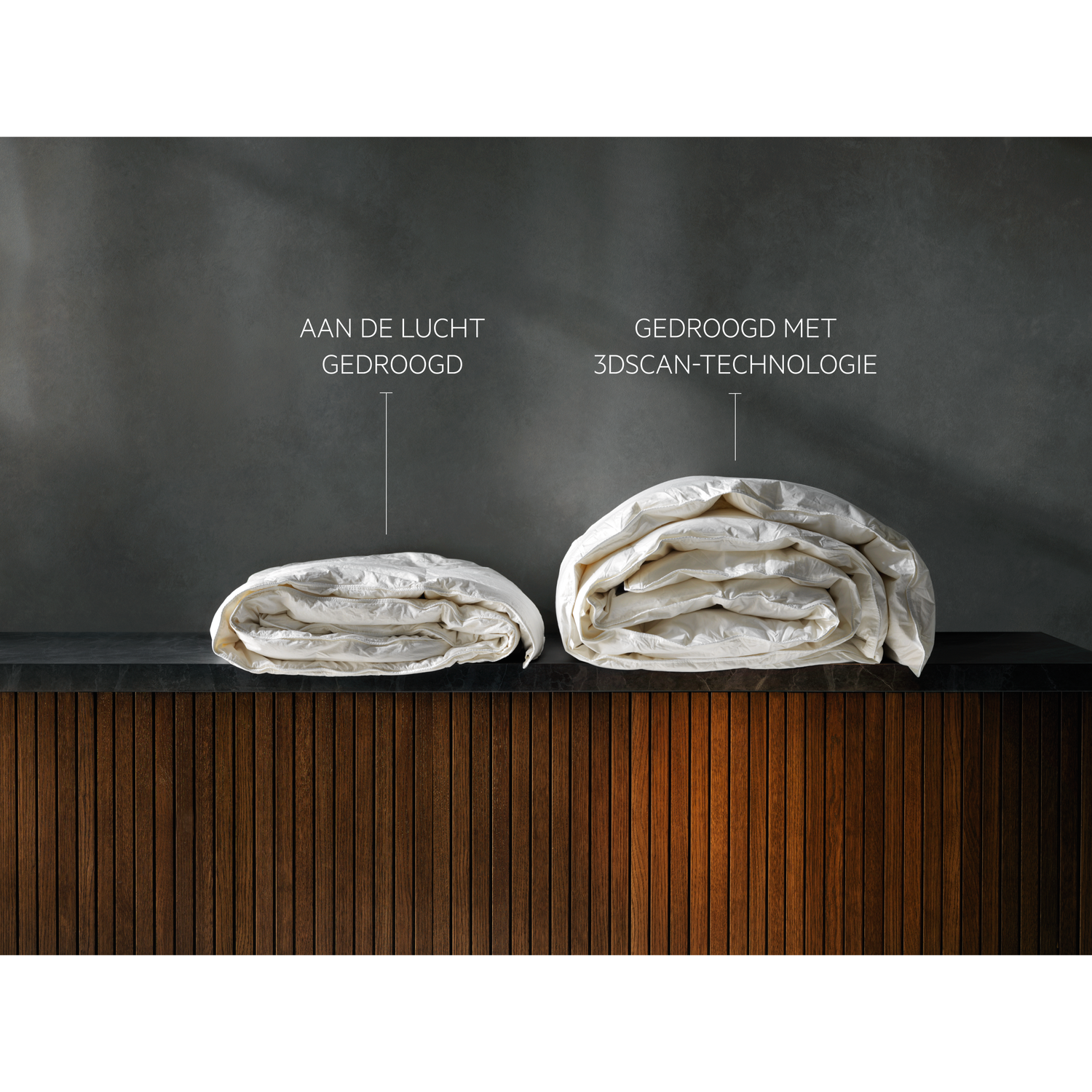 Two white folded duvets on a dark surface, one labeled 'air dried' and the other '3D scan technology dried' against a dark background.