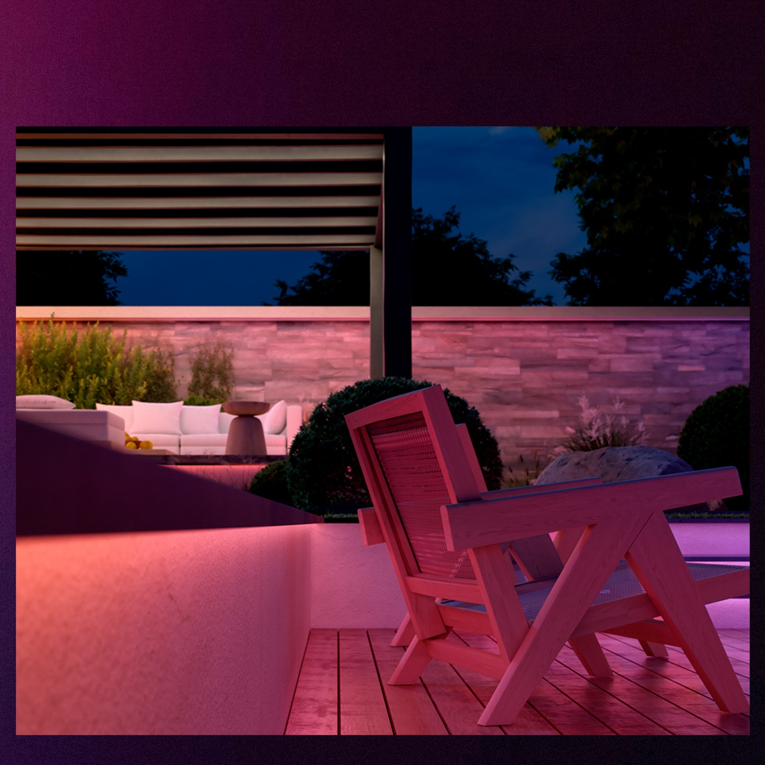 Wooden chair on a deck, with a patio in the background. Pink and purple lighting. Night scene. Couch and table visible.