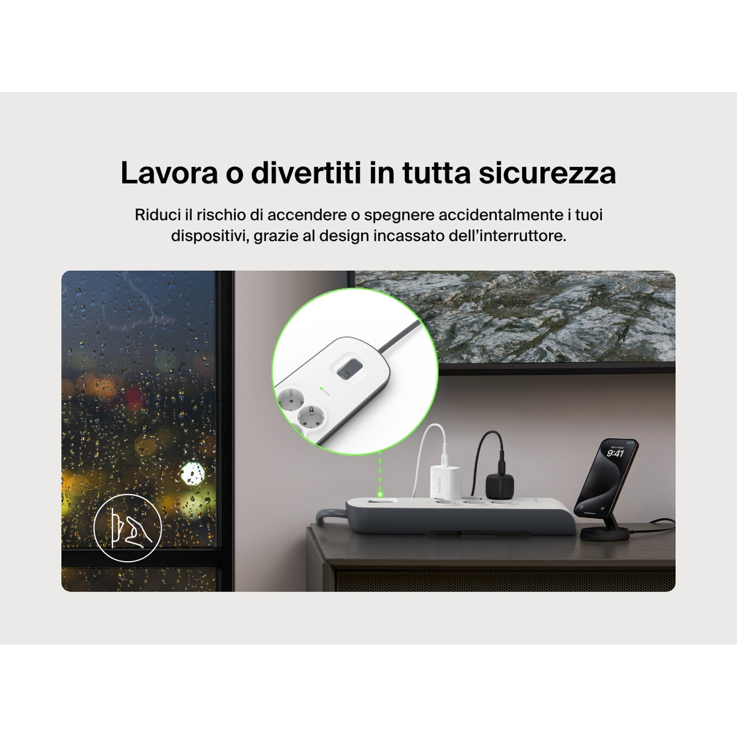 Una ciabatta con dispositivi in carica, un telefono su un supporto e una finestra con pioggia sono visibili.