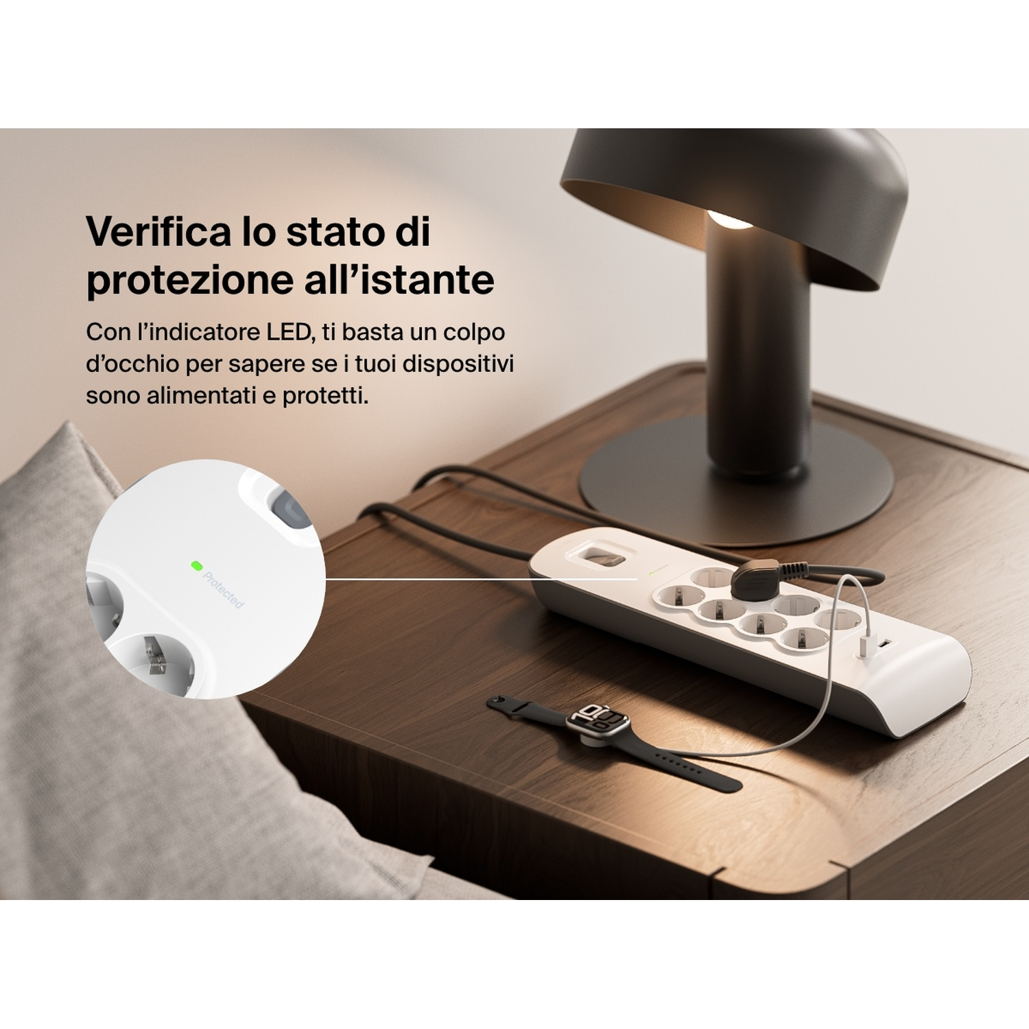 Un comodino con lampada, ciabatta, orologio e cavi. Testo: 'Controlla lo stato di protezione all'istante'.